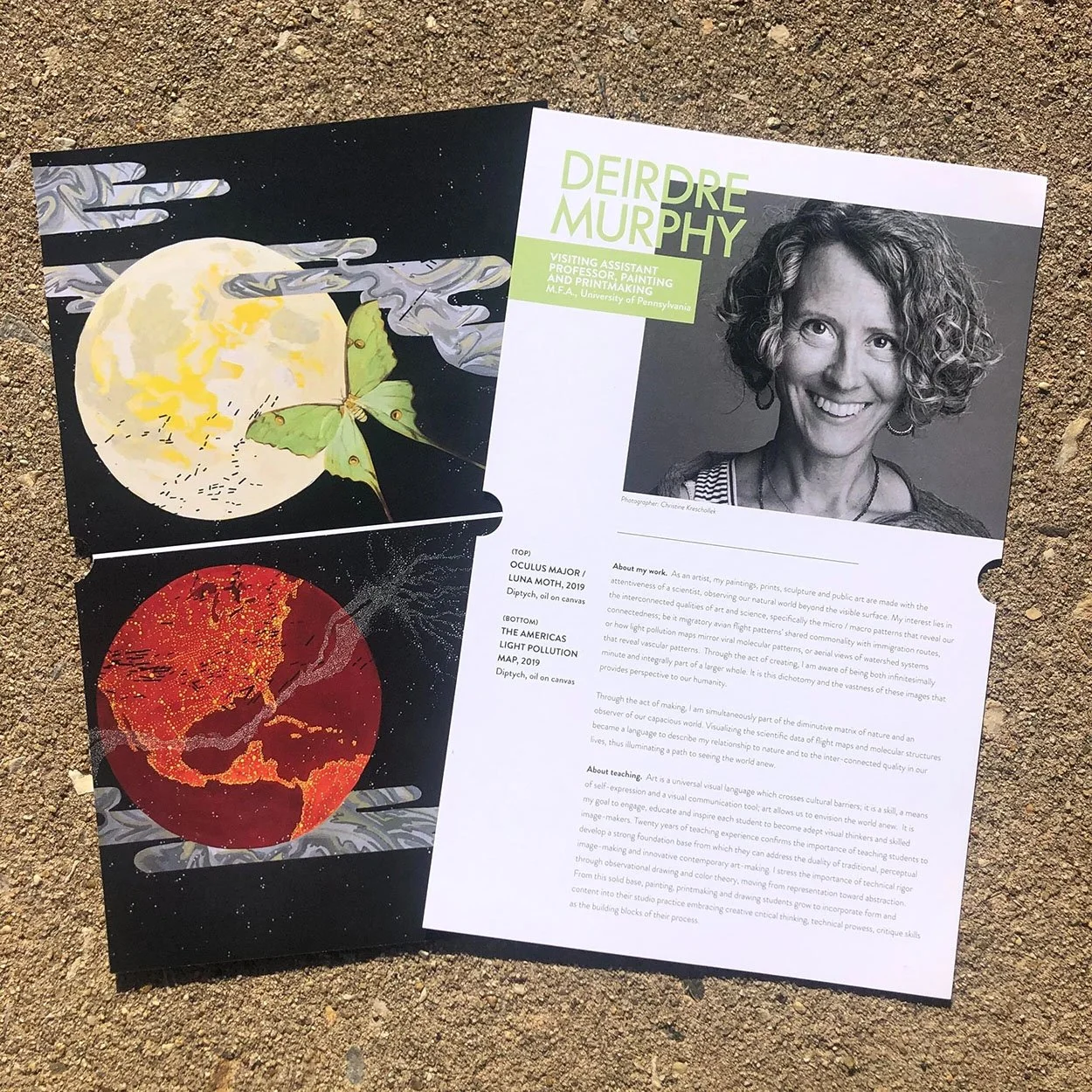 Two artistic posters on the ground, one depicting a moon with a butterfly and cloud-like patterns, and the other showing a red moon or planet with textured details, accompanied by a black-and-white portrait of a woman with curly hair and text about h