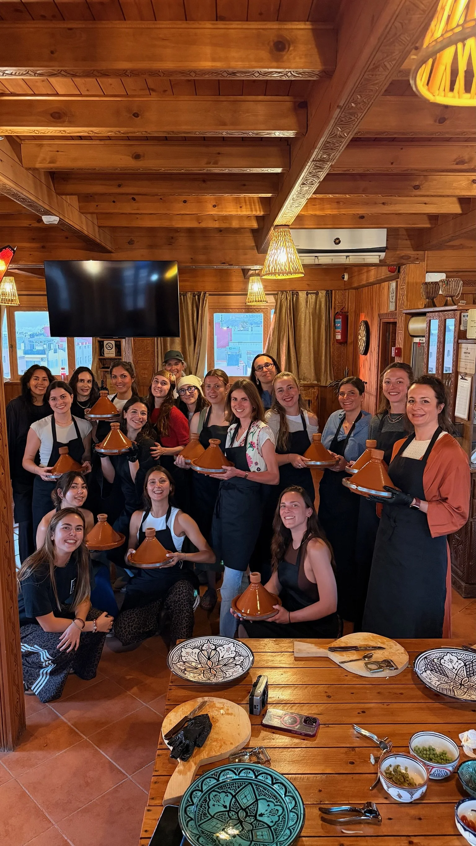 Groupe de femme en train lors d'un cours de cuisine marocaine organisée par Mona Retreats au Maroc. 