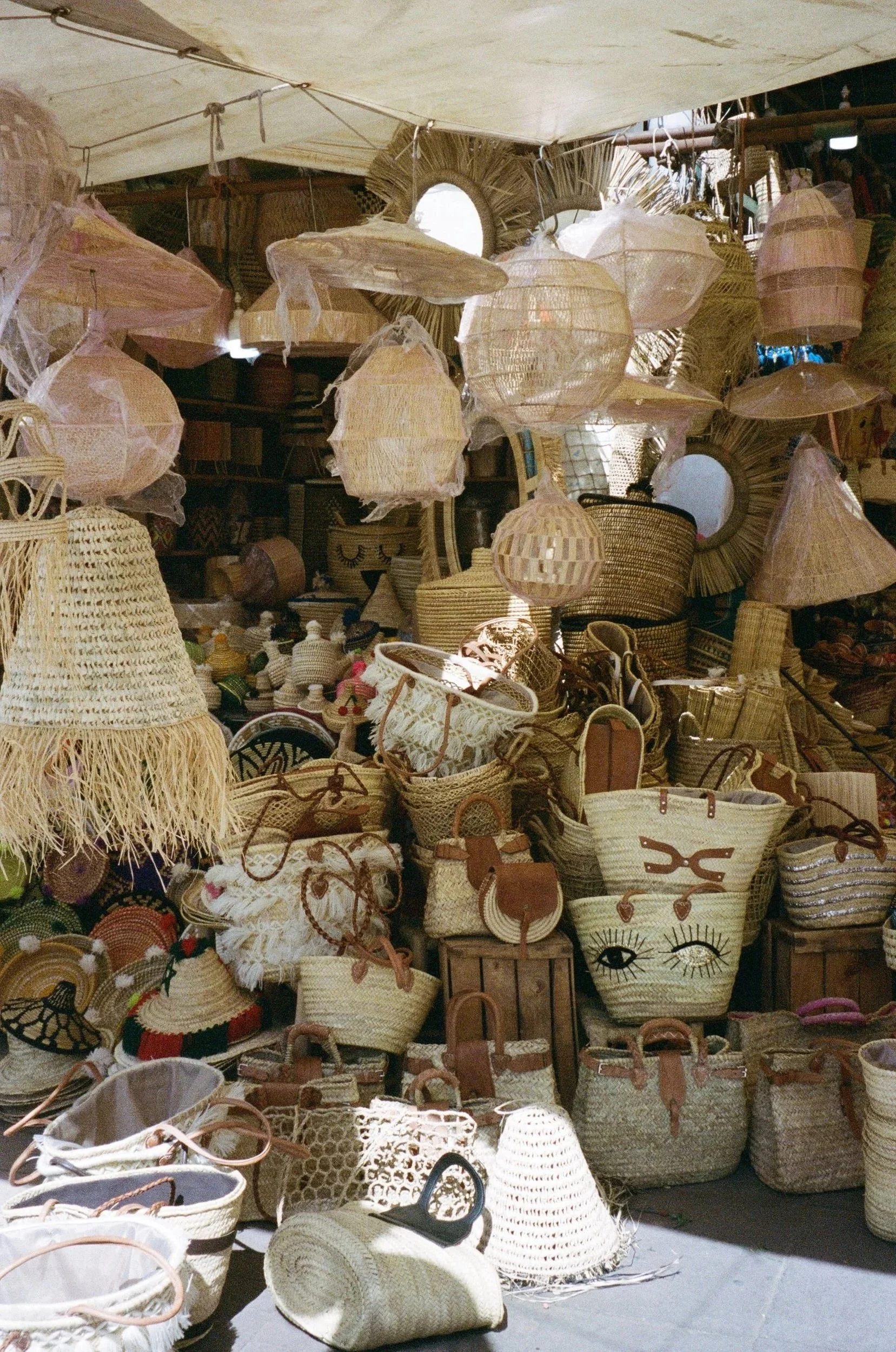 Vente de paniers en osier, sacs et chapeaux en rotin lors d'un marché outdoor.