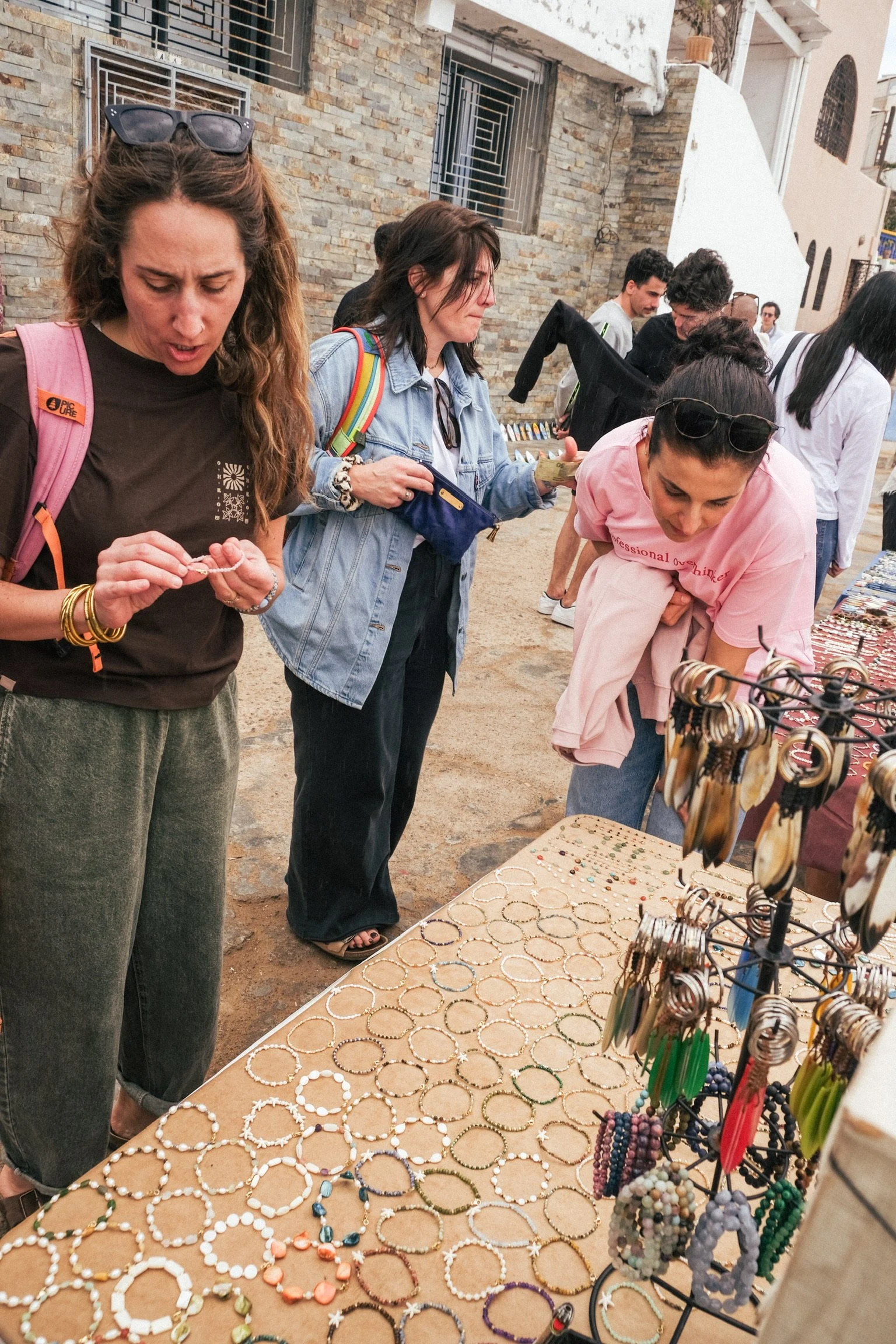 Participants découvrant un stand de bijoux et d’artisanat local lors d’une balade au Maroc, entre shopping, curiosité et immersion dans la vie locale.
