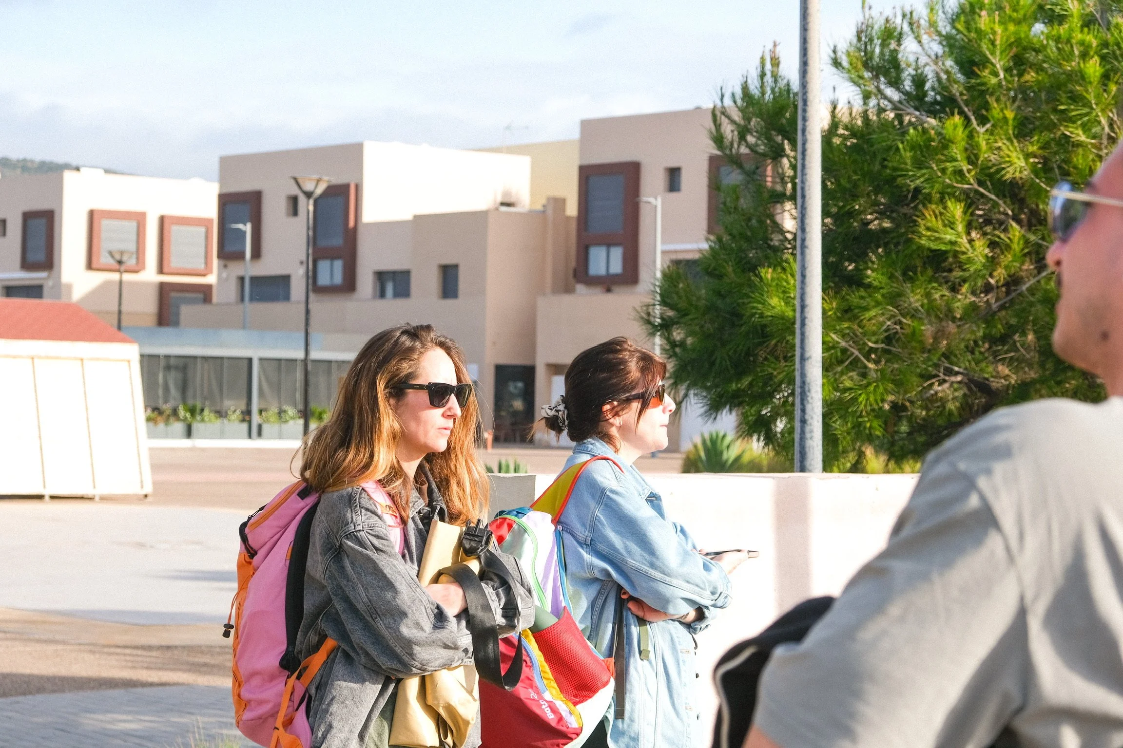 Participants équipés de sacs et serviettes, prêts à partir pour une activité en extérieur sous le soleil de Tamraght.