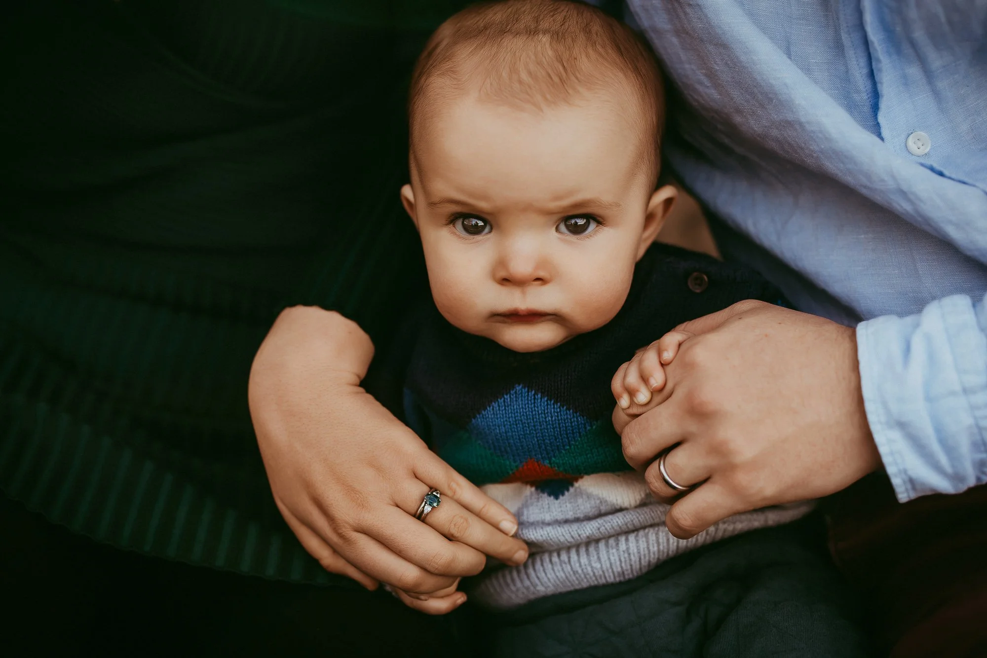 A young child with light skin, big brown eyes, and short light brown hair looks directly at the camera. Unposed Hobart family photography.
