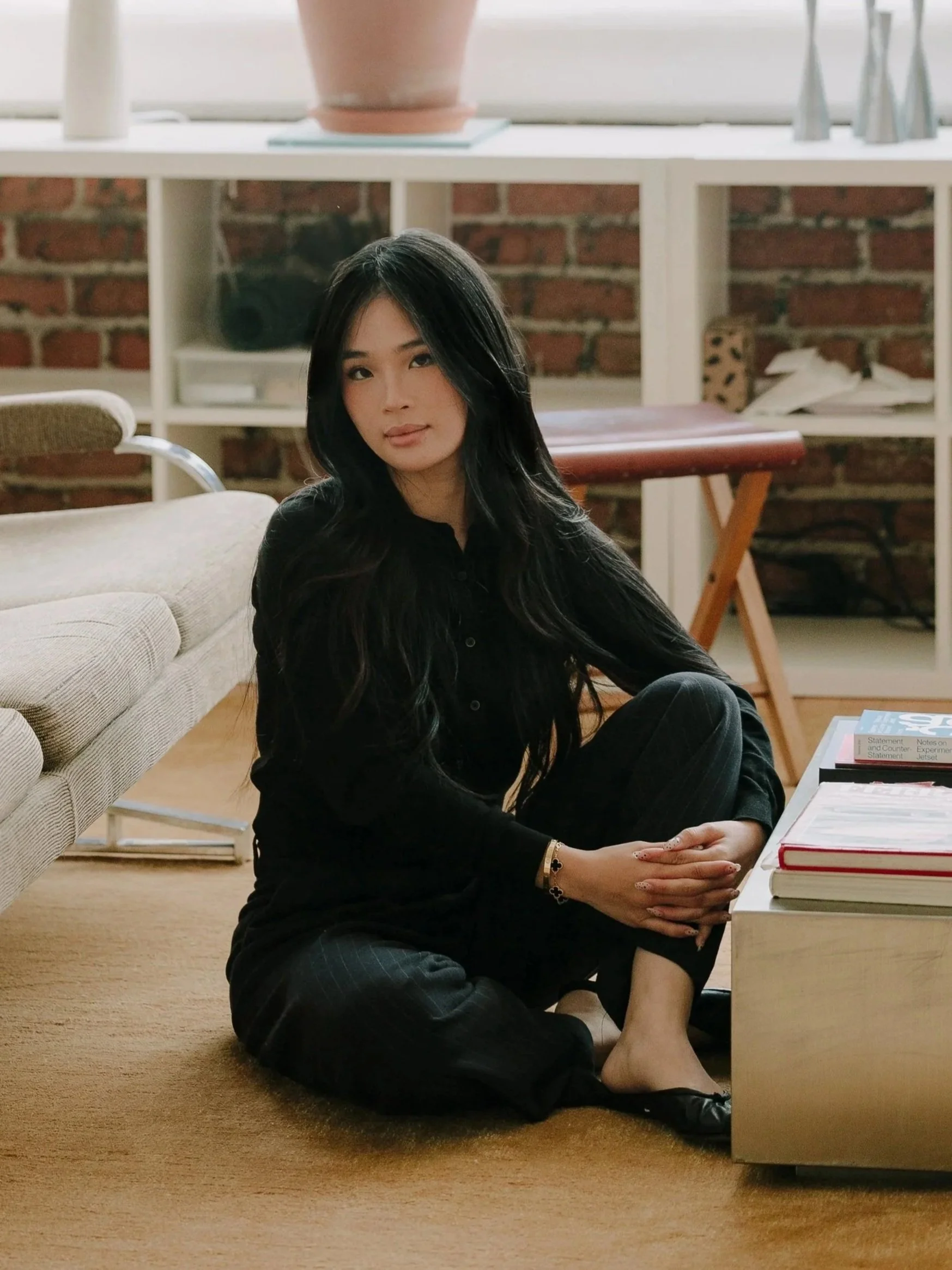 Tayler sitting on the floor next to a sofa.