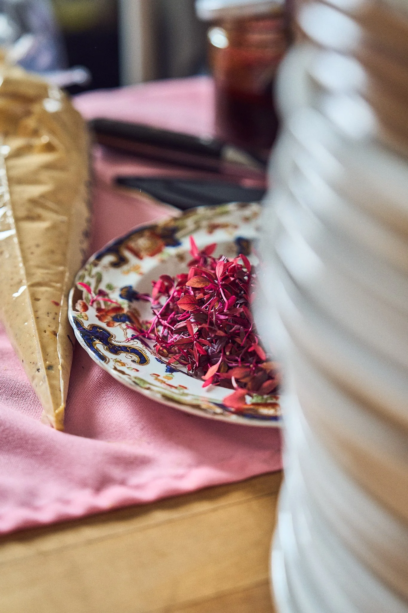 A decorative plate with pink and purple dried flowers, placed on a pink cloth. Photographed by Gumption Studio, Ottawa event photographer.
