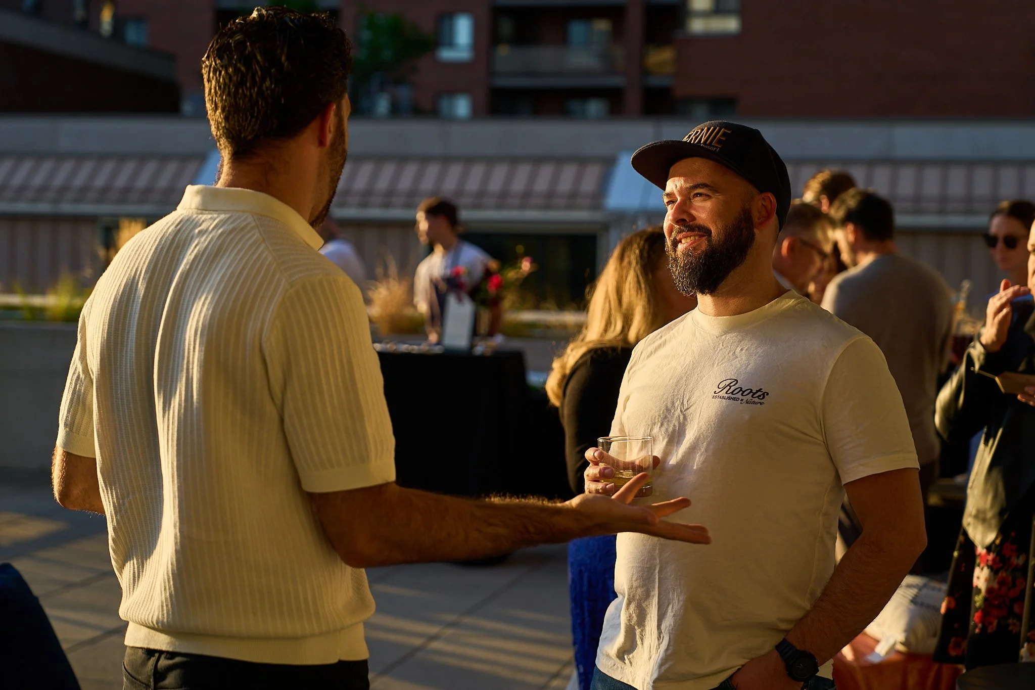 Two men are having a conversation at Harvest: A Feast of Fall during golden hour. Photographed by Gumption Studio, Ottawa event photographer.