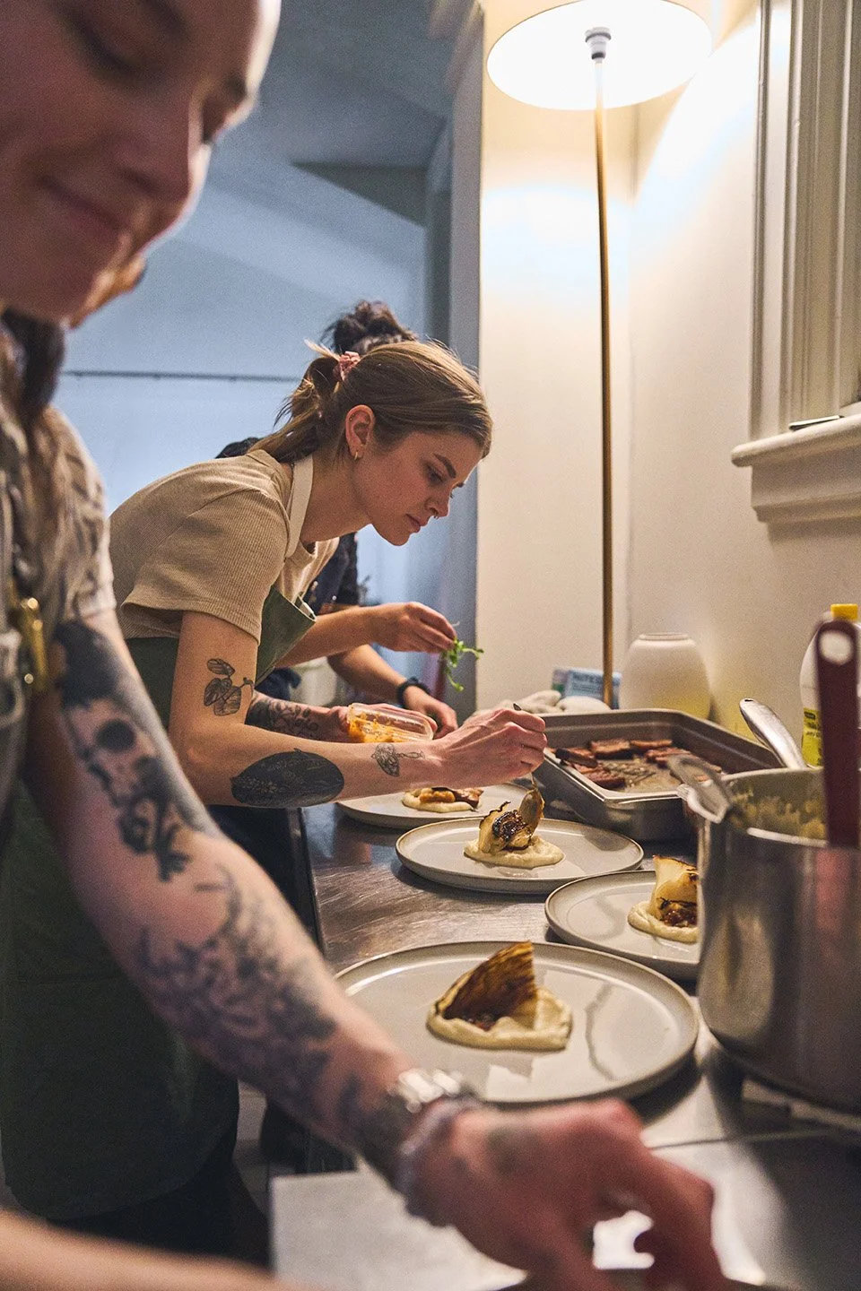 Chefs preparing plated dishes in at the Girl Dinner Event at Parlour Restaurant. Photographed by Gumption Studio, Ottawa event photographer.