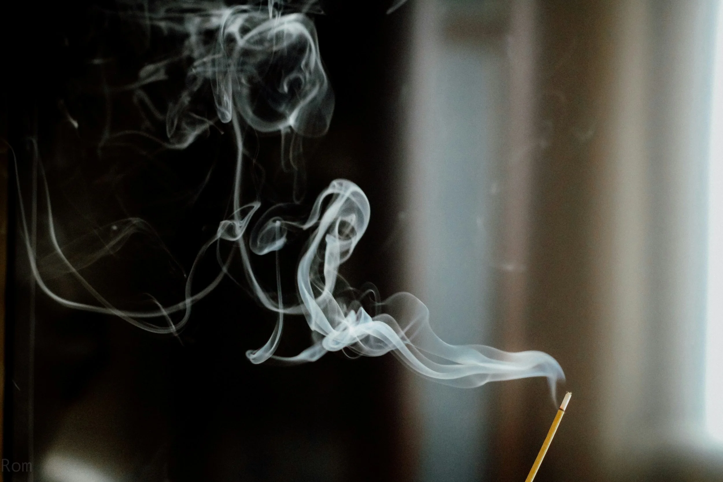 Whispy white smoke coming from an incense stick