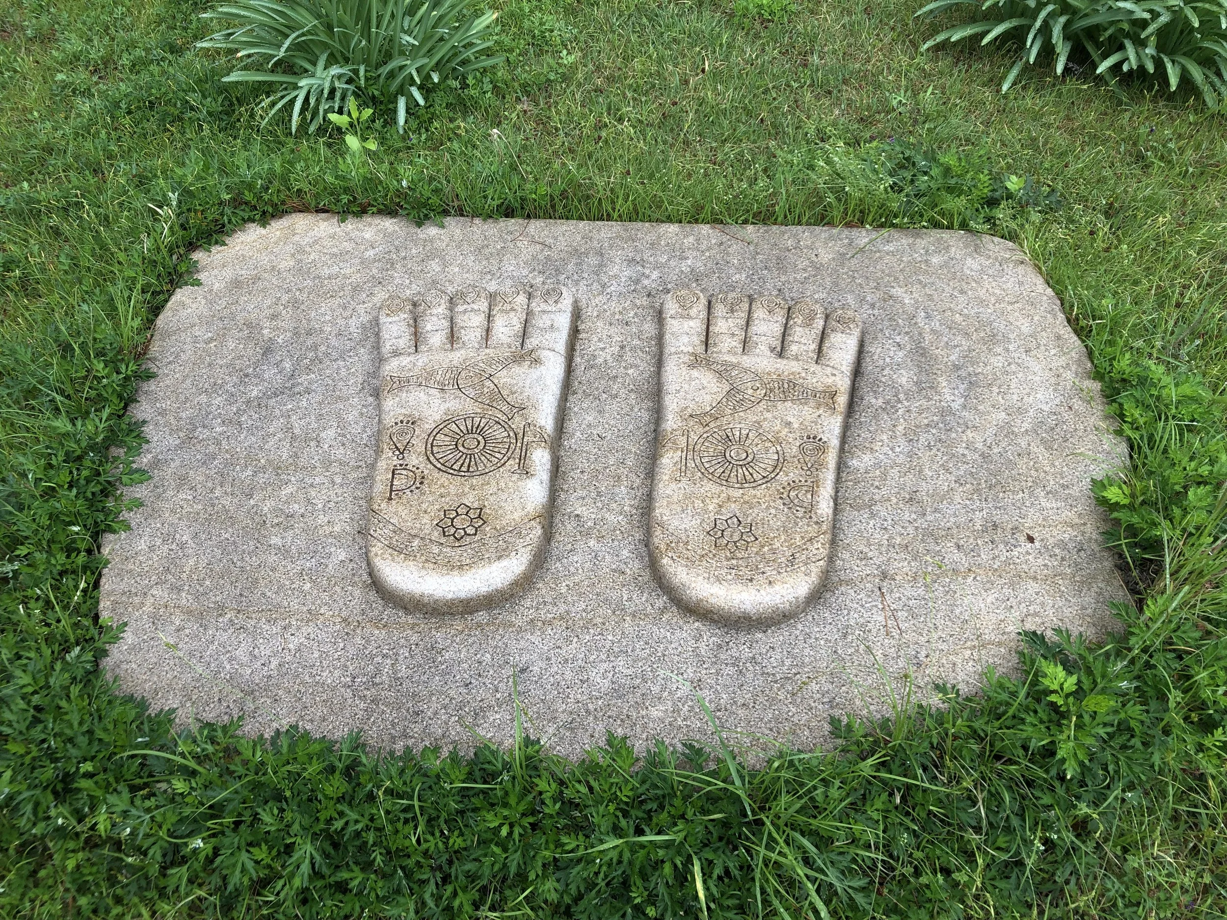 A statue of buddha's feet in rock