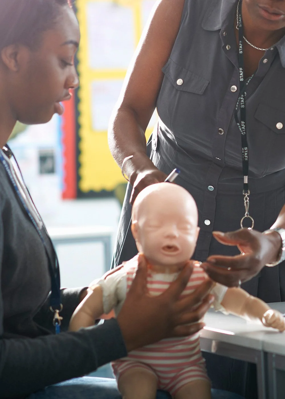 Instructor demonstrating infant CPR using a baby manikin