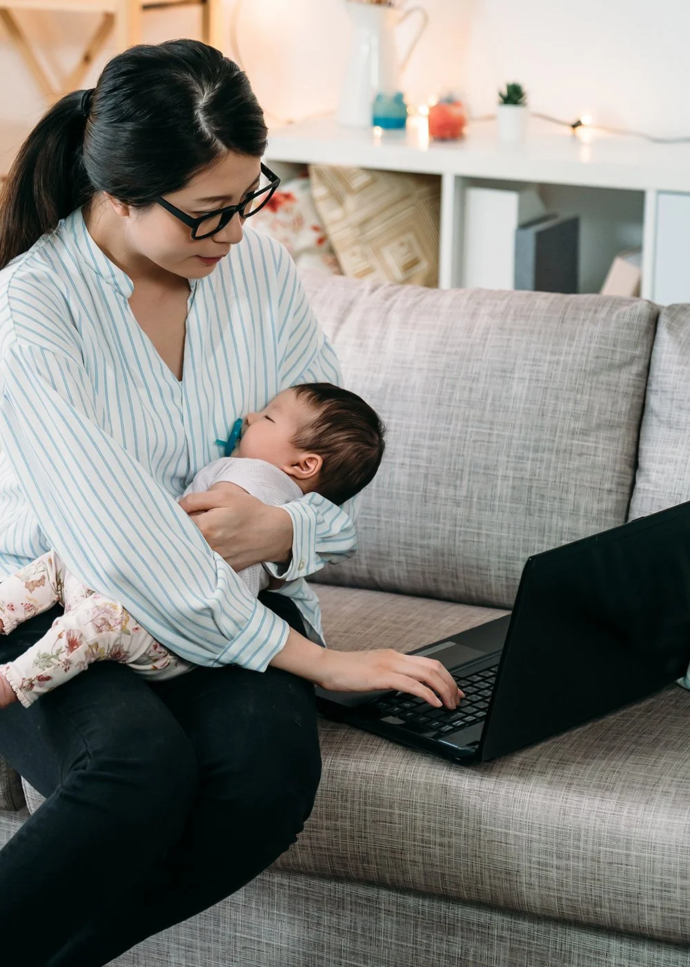 Parent and infant on a couch during a virtual lactation session