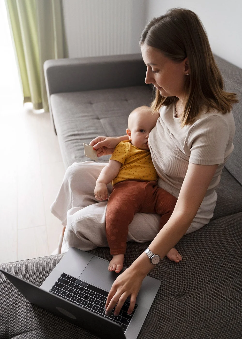 Parent and infant on a couch during a virtual lactation session