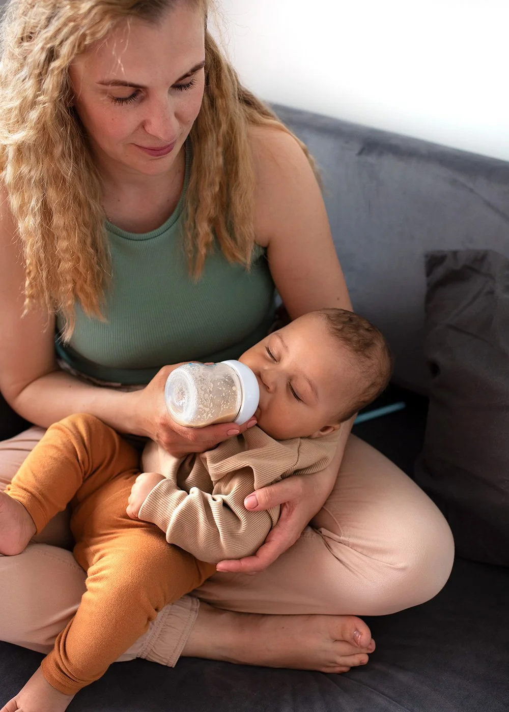 Parent cradling and gazing at their baby in a peaceful moment while bottle-feeding