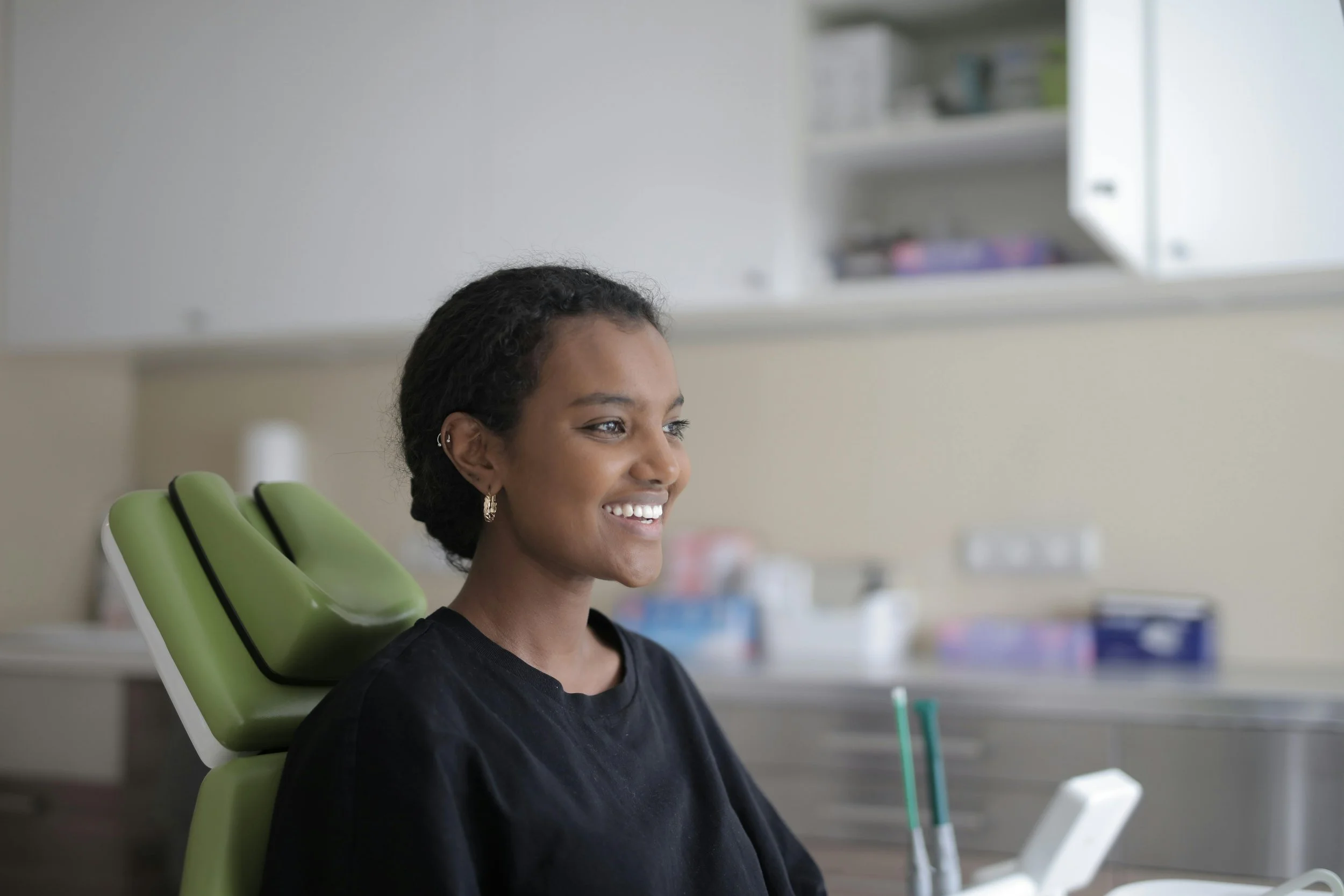 Confident woman smiling in dentist chair after treatment