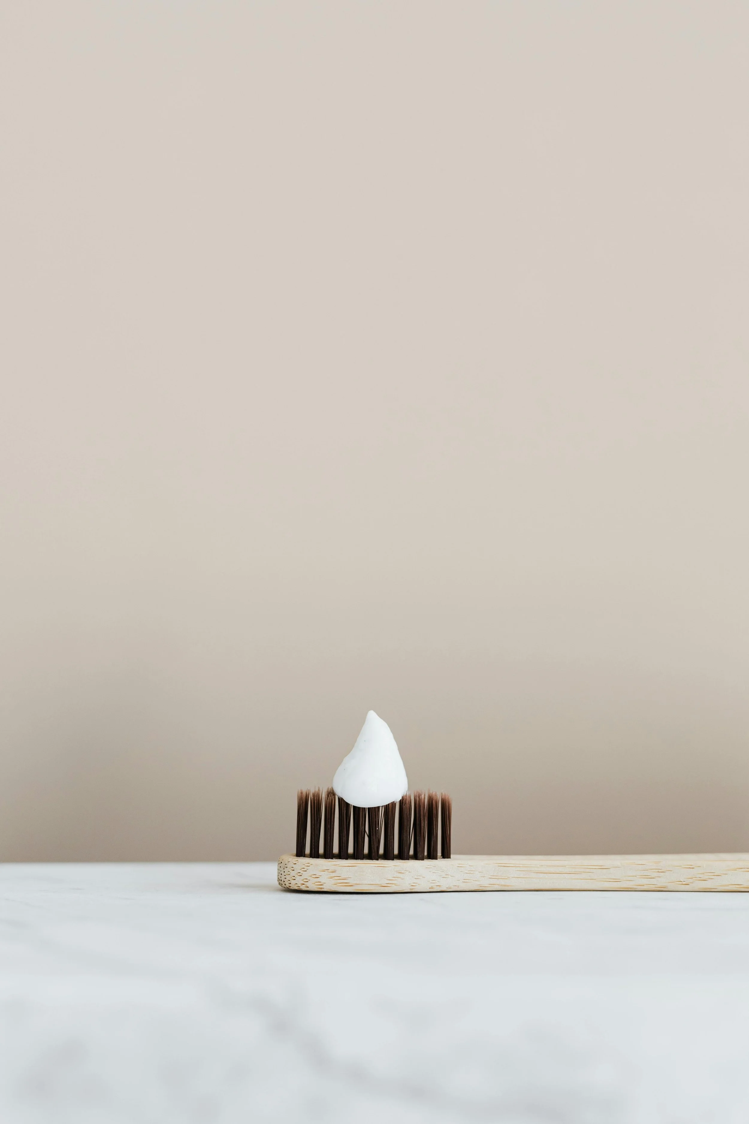 Sustainable bamboo toothbrush with natural toothpaste applied.