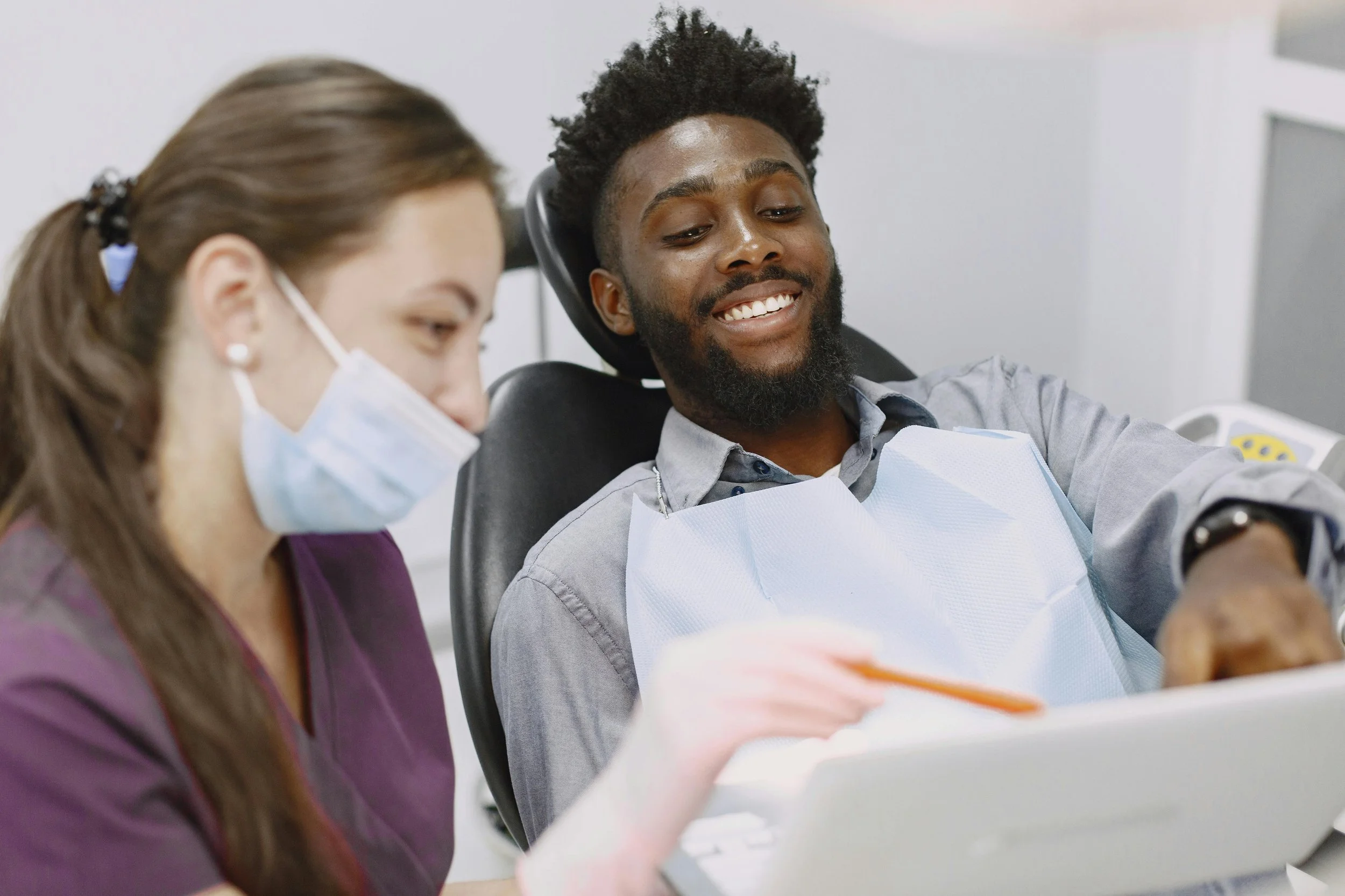 Male patient smiling with dentist during consultation