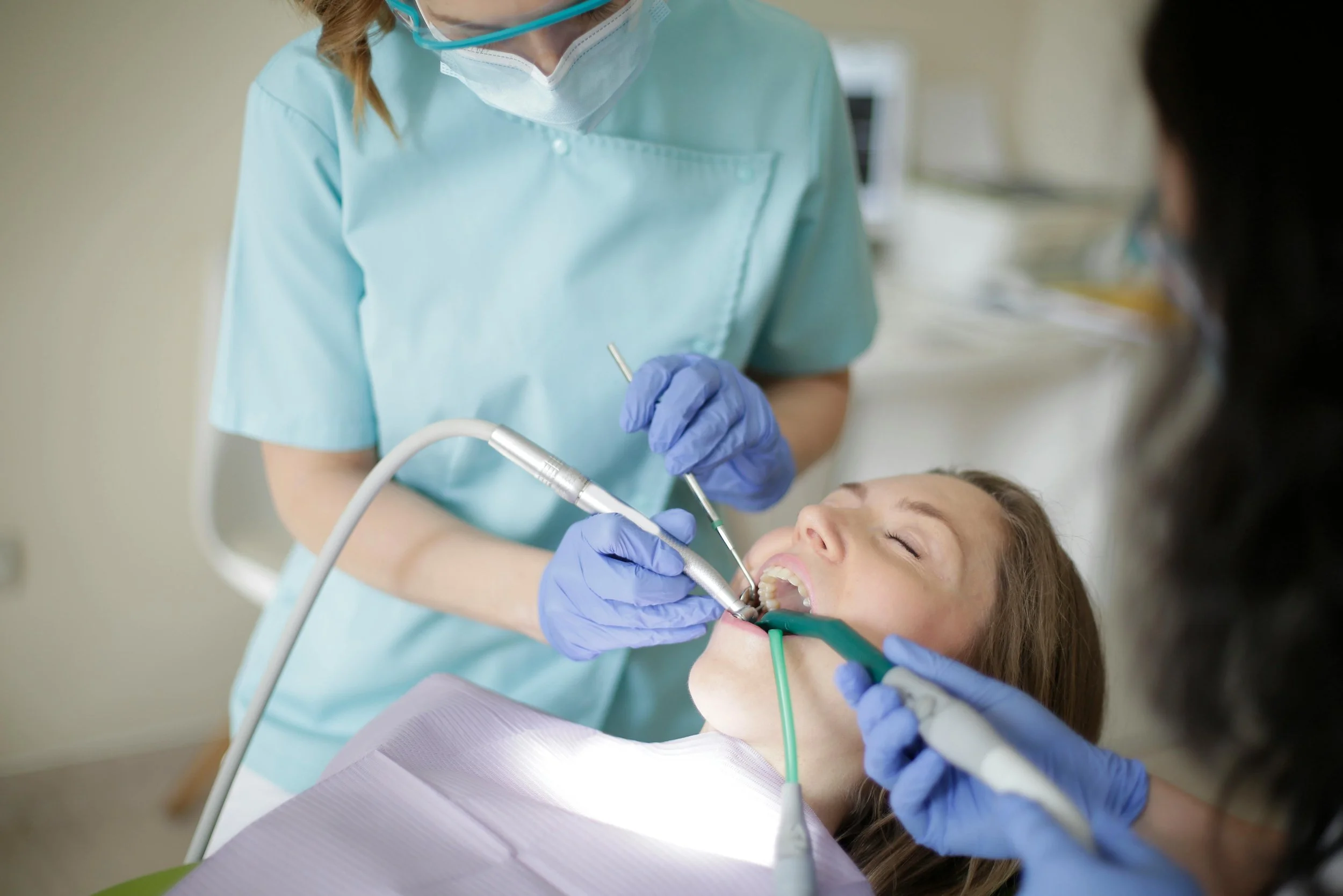 Close-up of dentist and assistant working on patient’s teeth