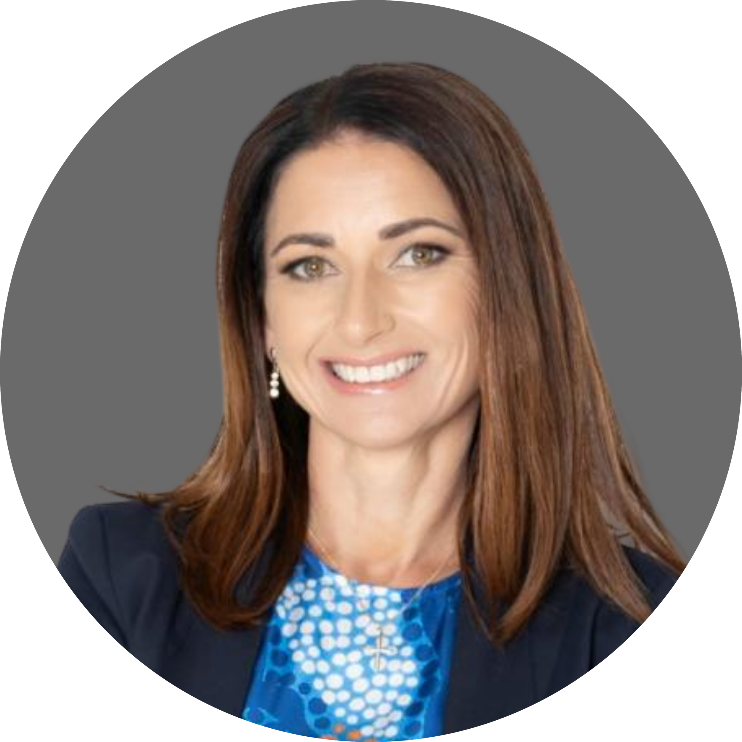 Circular headshot of Jahna Cedar OAM GAICD, a woman with long brown hair, smiling at the camera. She wears a blue top with a dotted pattern and a navy blazer, set against a grey background.