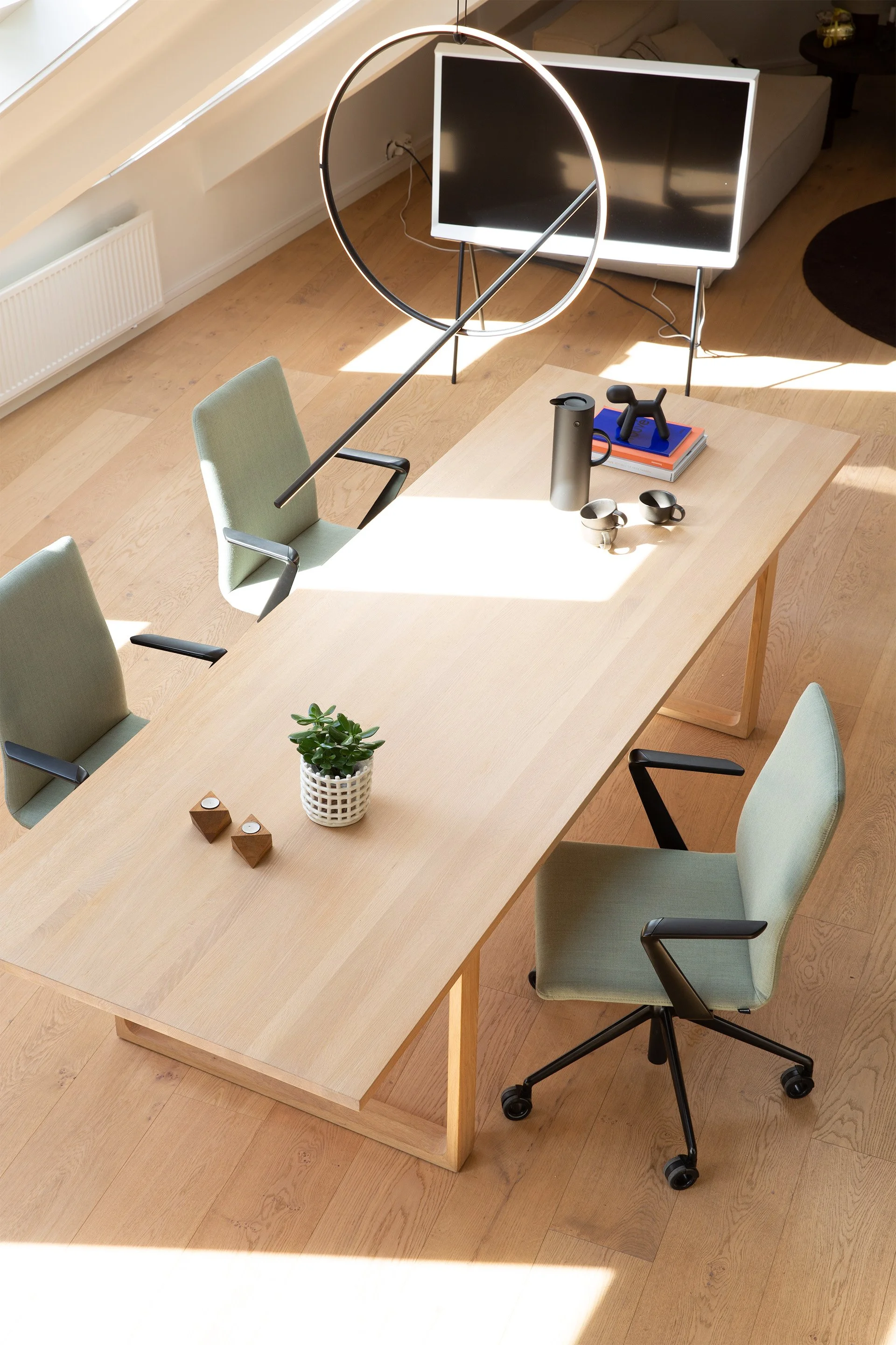 Scenic view of snow-capped mountains behind a grassy hillside, with a modern building in the foreground.