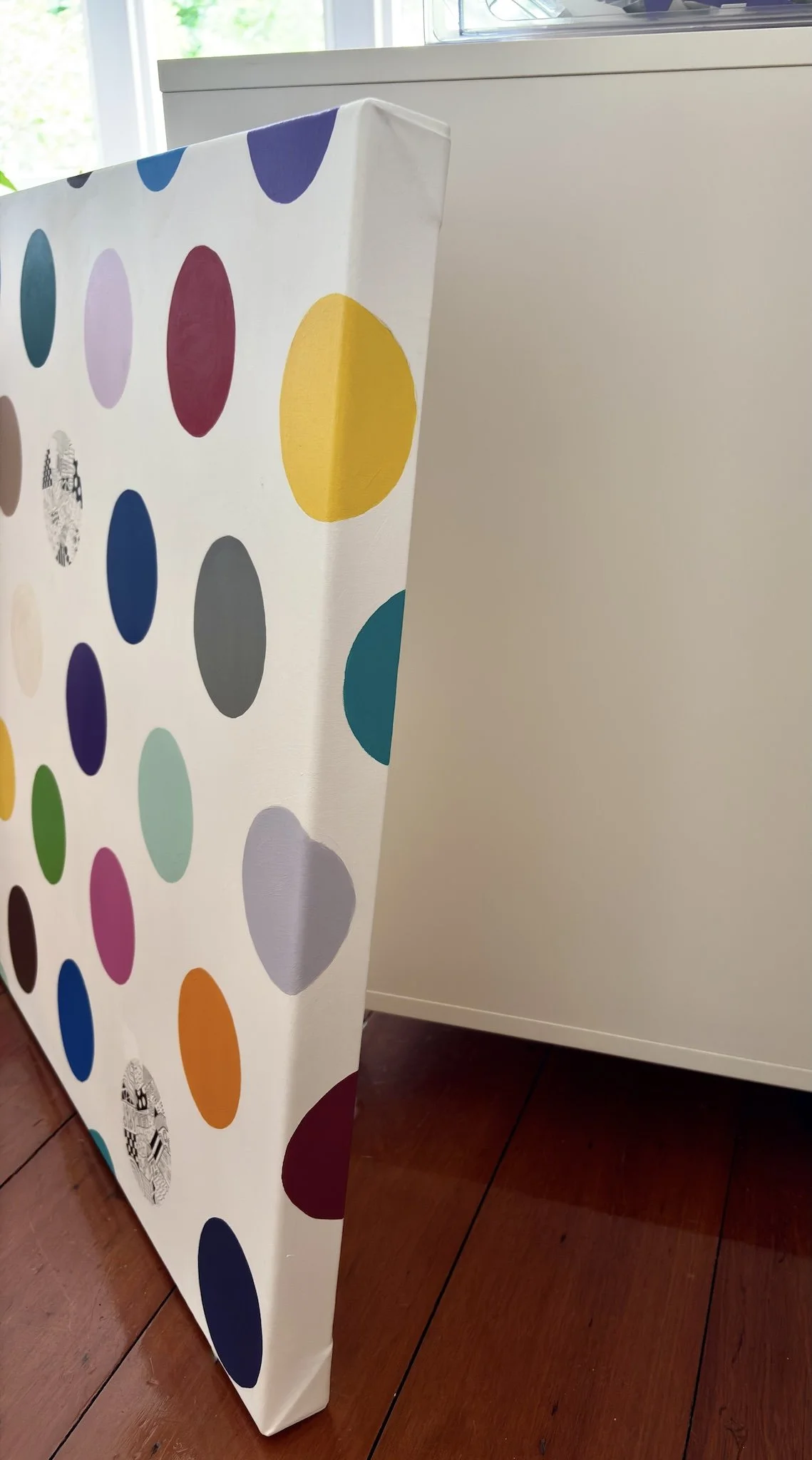 Spot The Happy Smile, original mixed media abstract on canvas with a white background and colourful spots, close-up detail, side view.