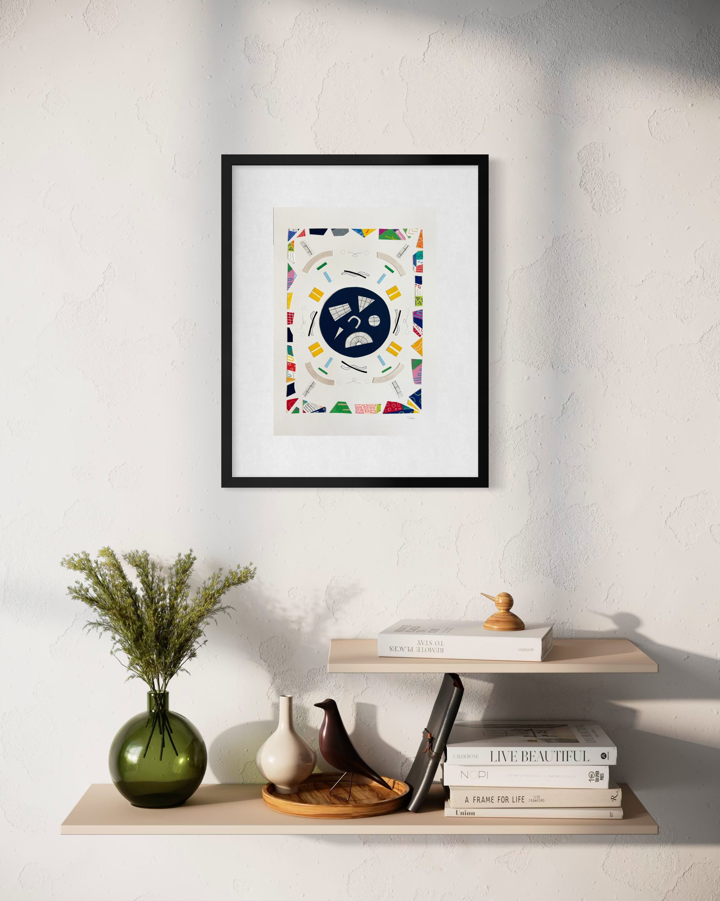 A Measured Arrangement, A3 abstract mixed media collage with central pen drawings and painted fragments, framed by a border of acrylic marker and gel pen pieces framed and displayed above a table.