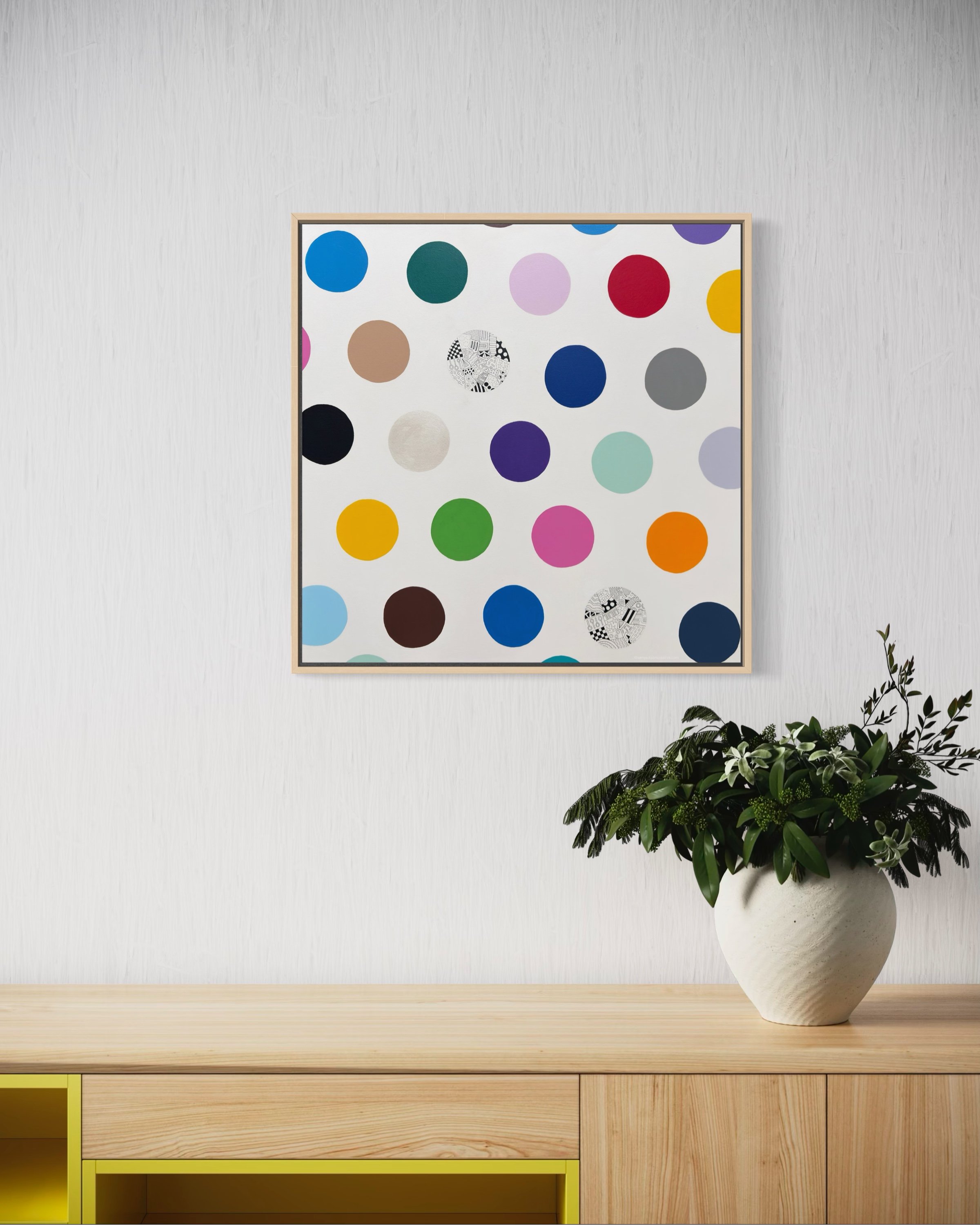 Spot The Happy Smile, original mixed media abstract on canvas with a white background and colourful spots, displayed on a wall near a pot plant.