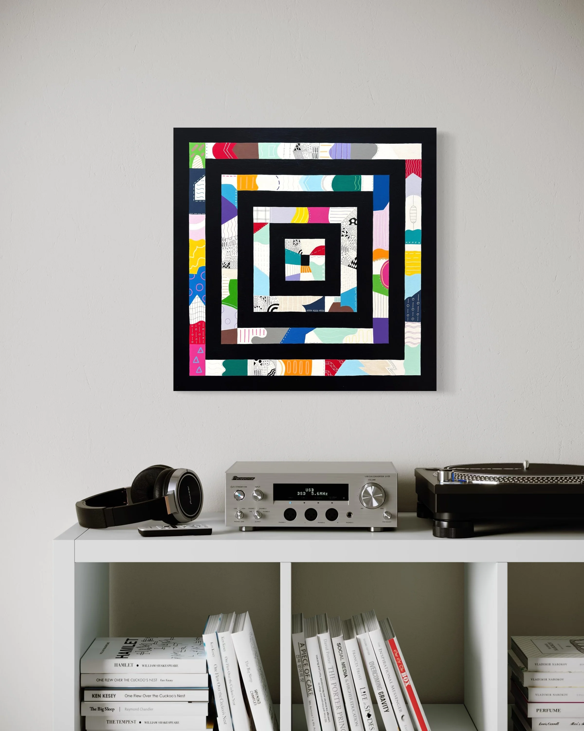 Freedom Within Boundaries, original abstract artwork on canvas featuring nested square frames in Paynes grey filled with bold, playful patterns and colour, styled above a modern storage unit.