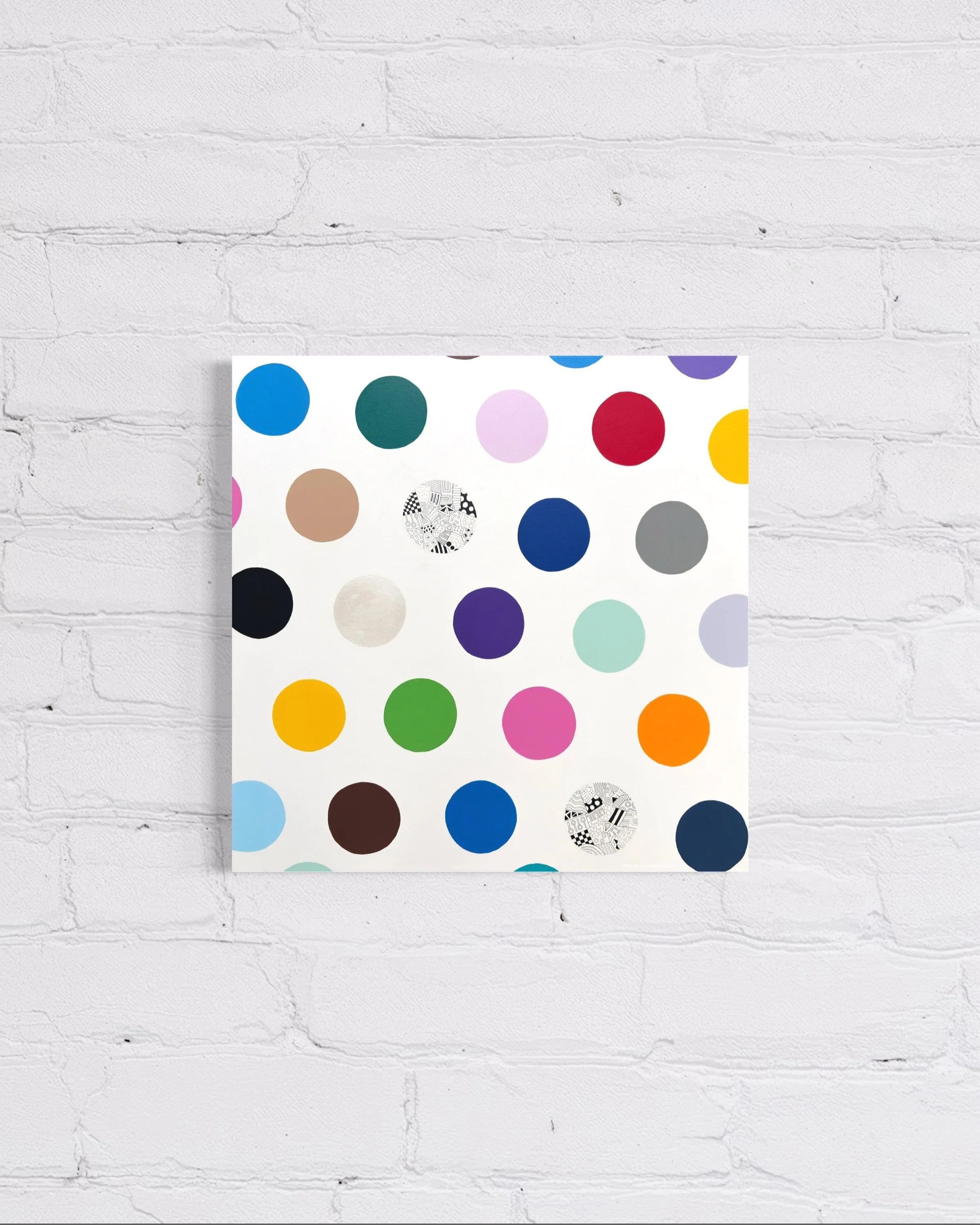 Spot The Happy Smile, original mixed media abstract on canvas with a white background and colourful spots, displayed on a white brick wall.