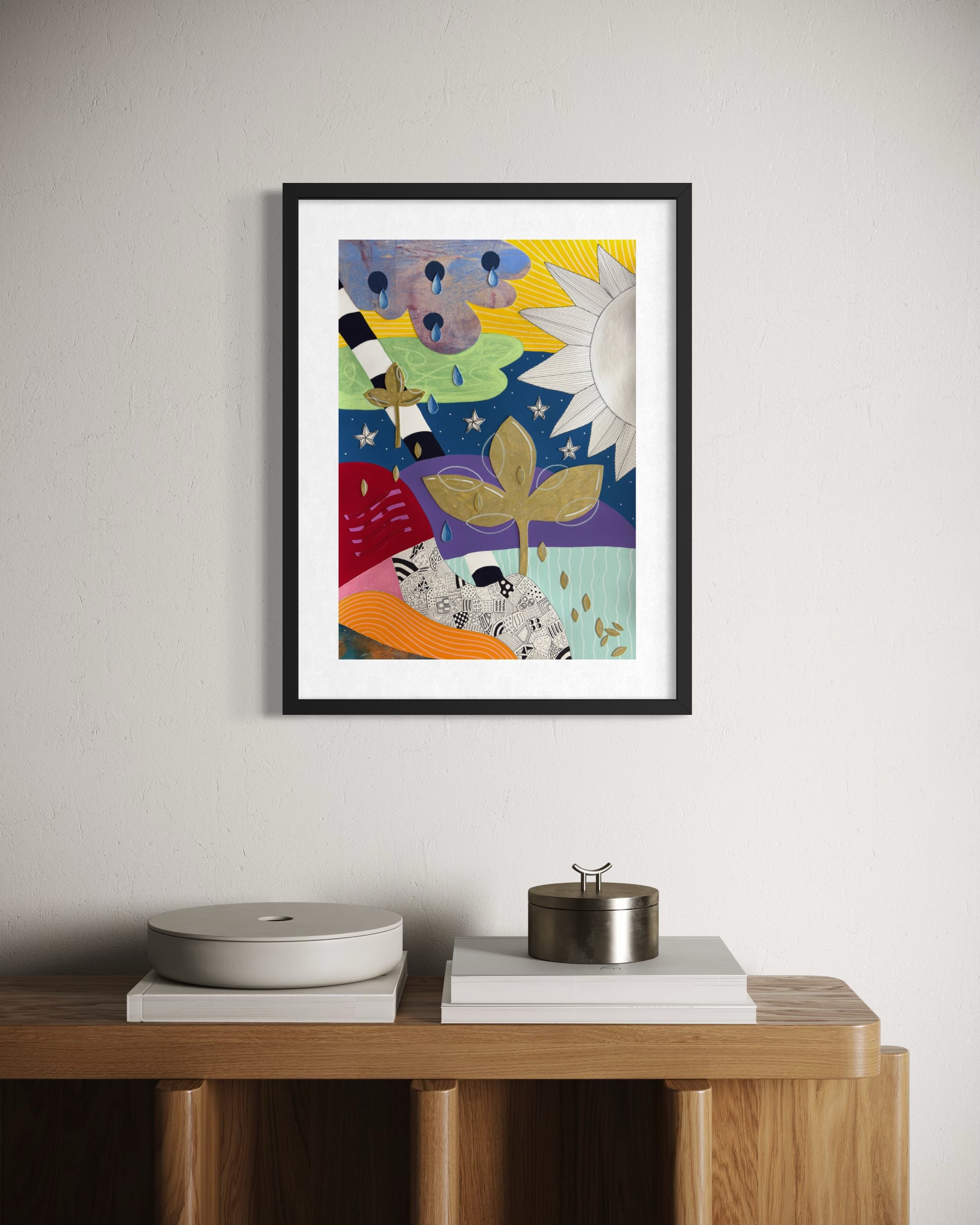 Tears To Gold, original mixed media abstract artwork on A3 paper featuring a sun, teardrops, stars, gold plant motifs and colourful sections, displayed framed in a modern interior.