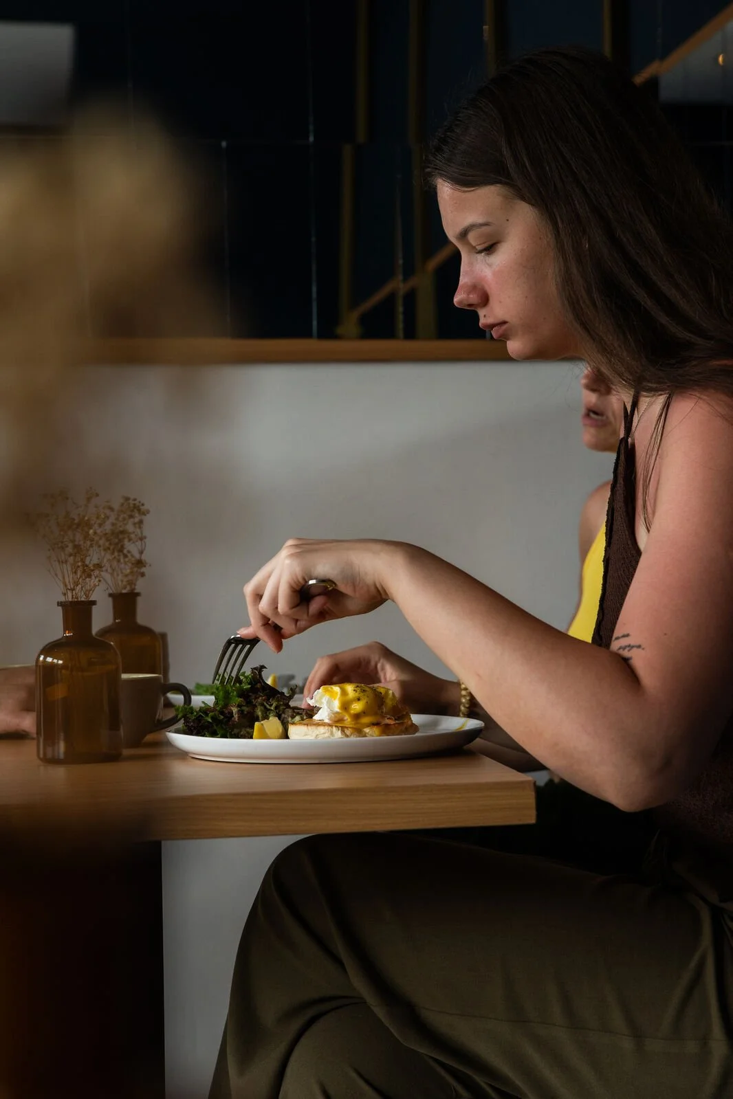 Guest enjoying Salmon Egg Royale at Studio Egg Ubud — poached eggs with smoked salmon, garlic shimeji and miso hollandaise on English muffin, Ubud Bali