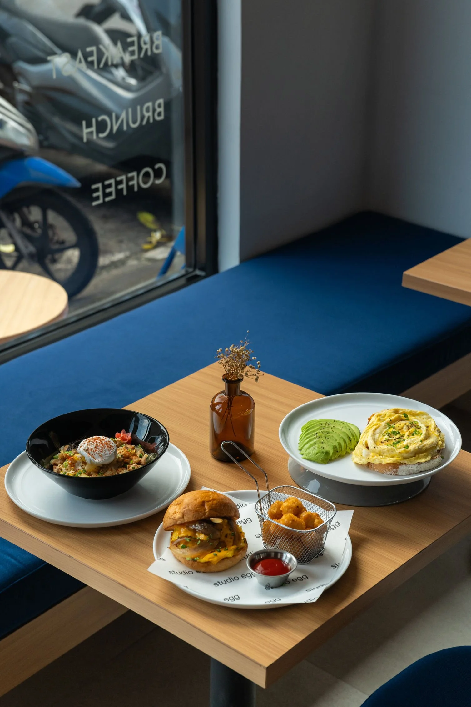 Organic free range egg brunch spread at Studio Egg in Ubud featuring Oyakodon, Egg Sandwich with Tater Tots, and Velvet Egg with Avocado and Toast