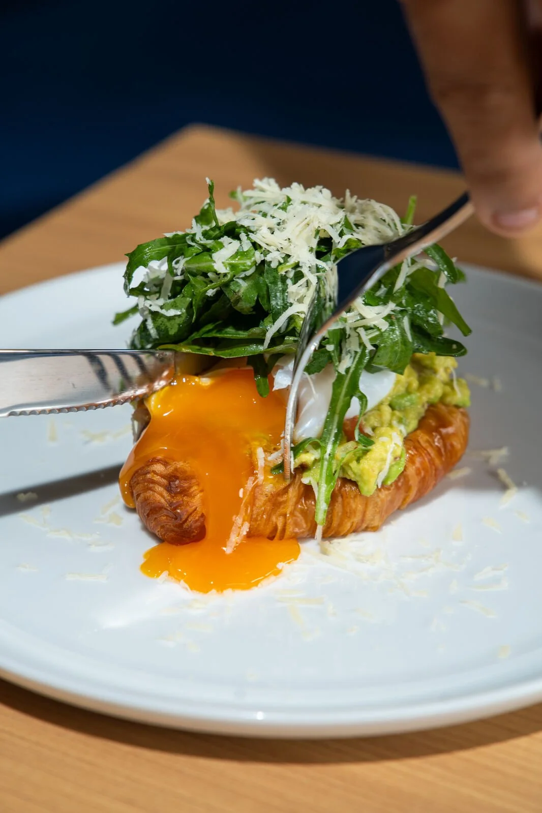 Avocado Croast with poached duck egg, guacamole, organic rucola and grated parmesan on butter croissant toast at Studio Egg cafe Ubud Bali