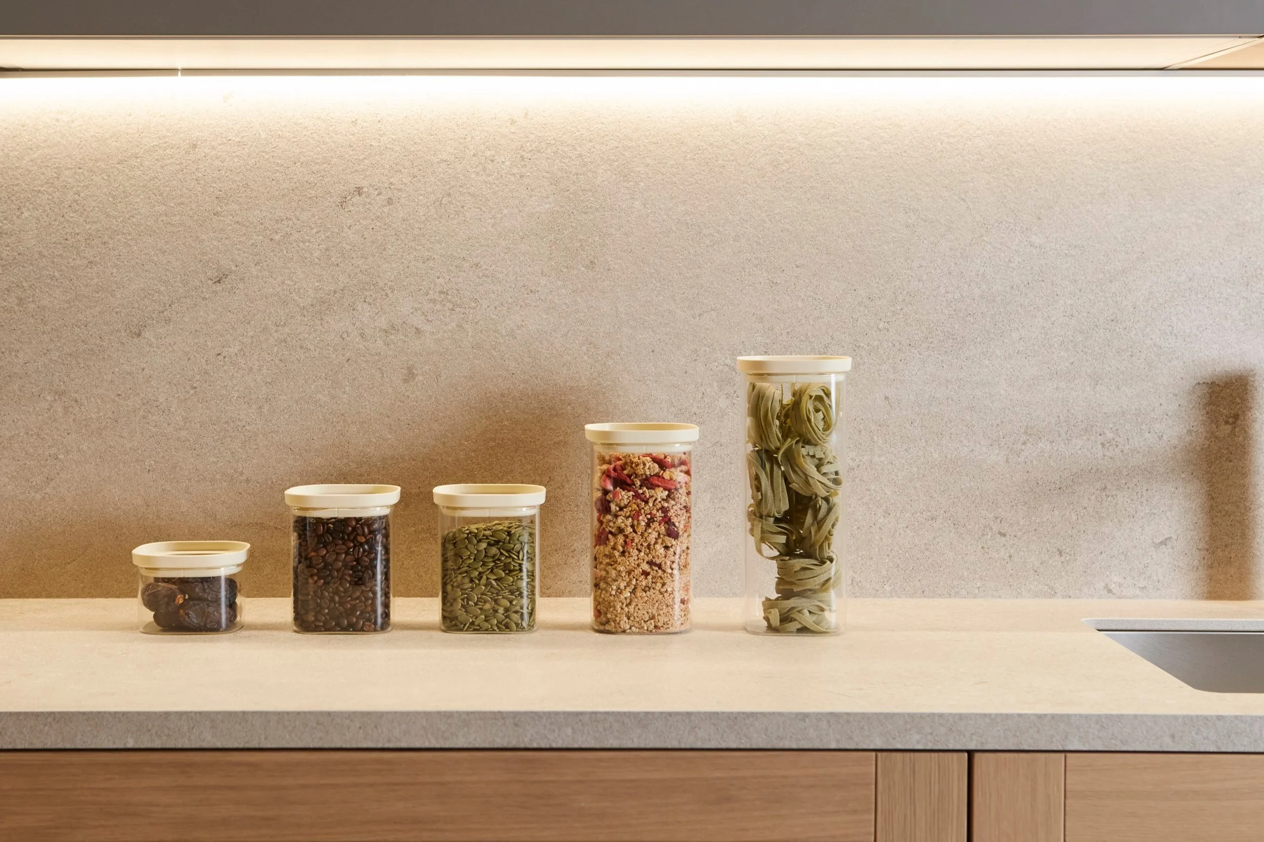 Dalena Home storage jars filled with coffee, seeds, granola and pasta on a stone countertop