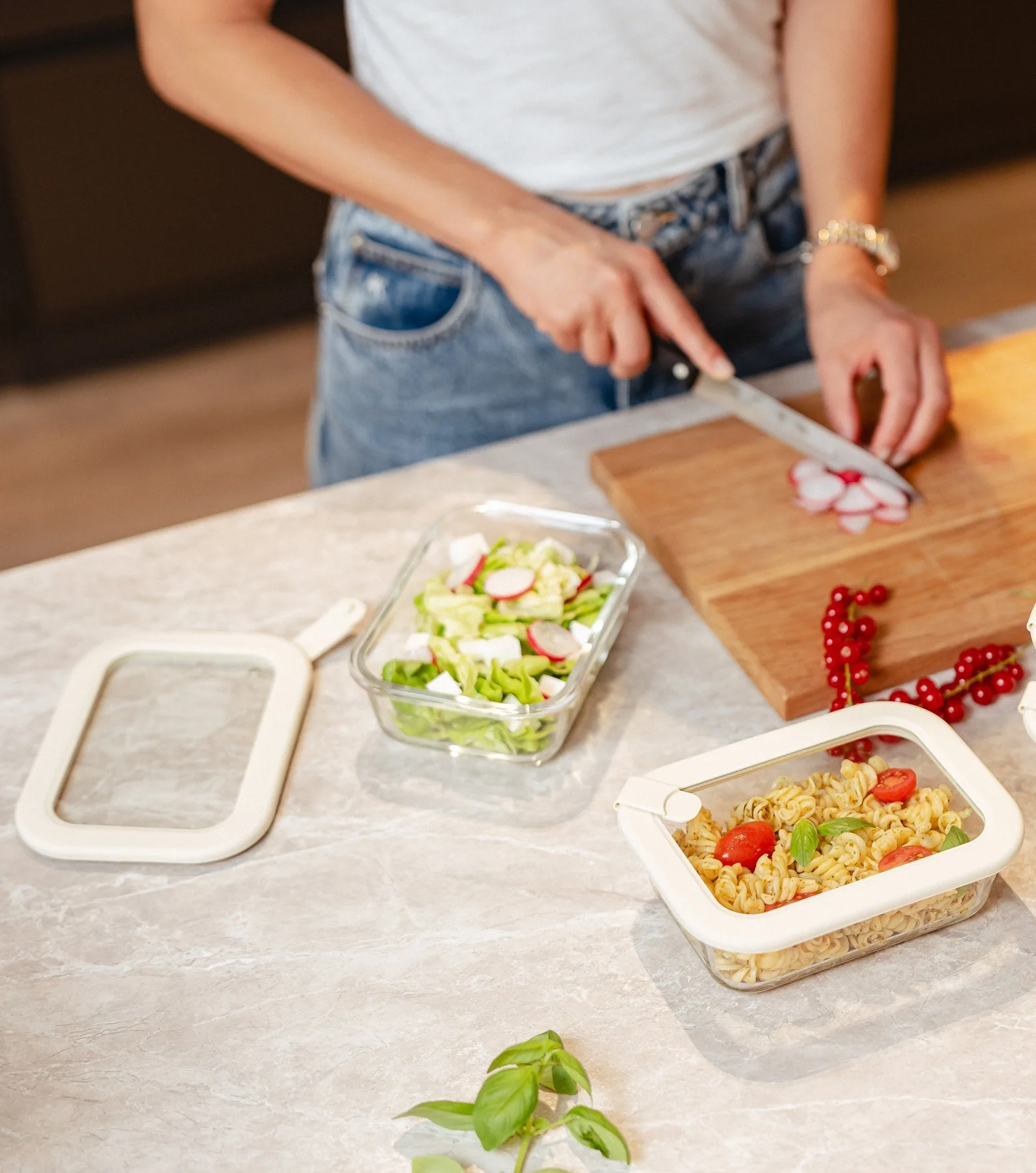Meal prep with Dalena Home glass food containers: salad, pasta and a spare lid on a kitchen counter