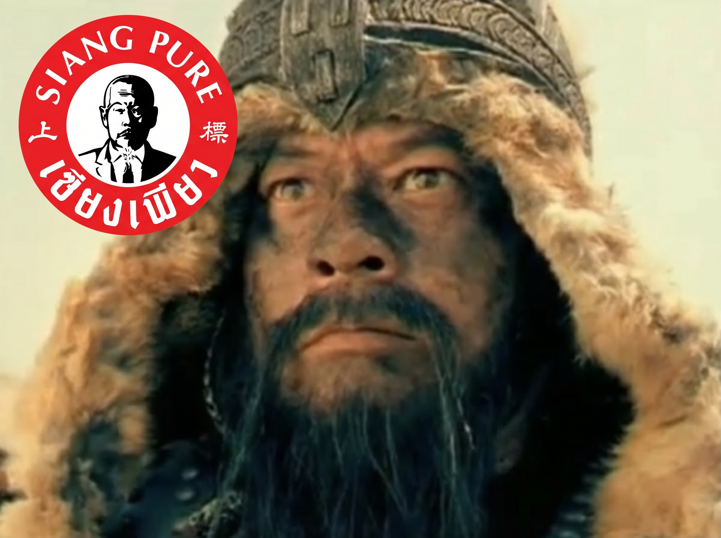Partial view of a native American man with a large fur hat and traditional attire, standing against an indoor background.