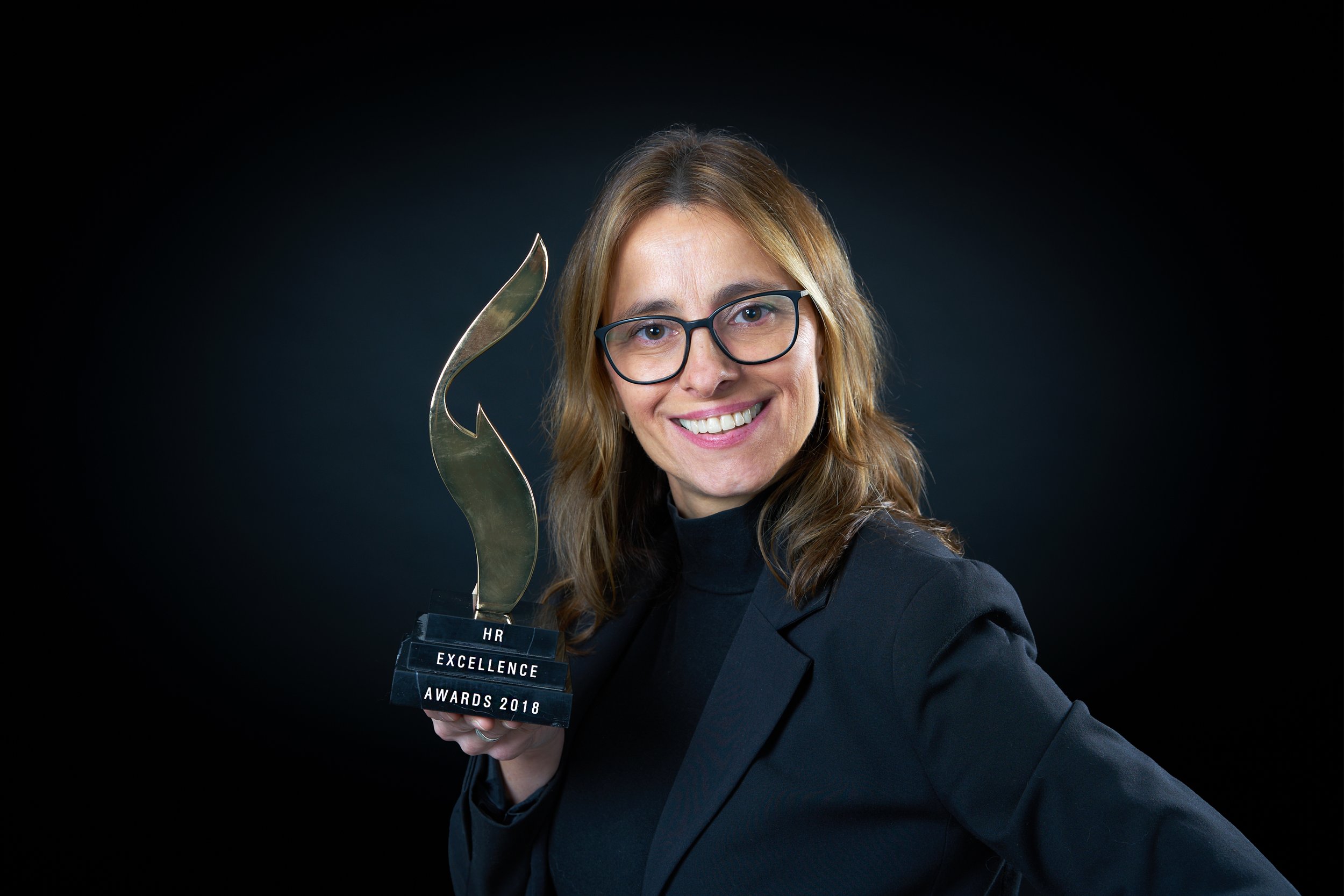 Iris Wagner hält einen schwarzen Award mit goldenen Silhouetten und schreibt: HR Excellence Awards 2018