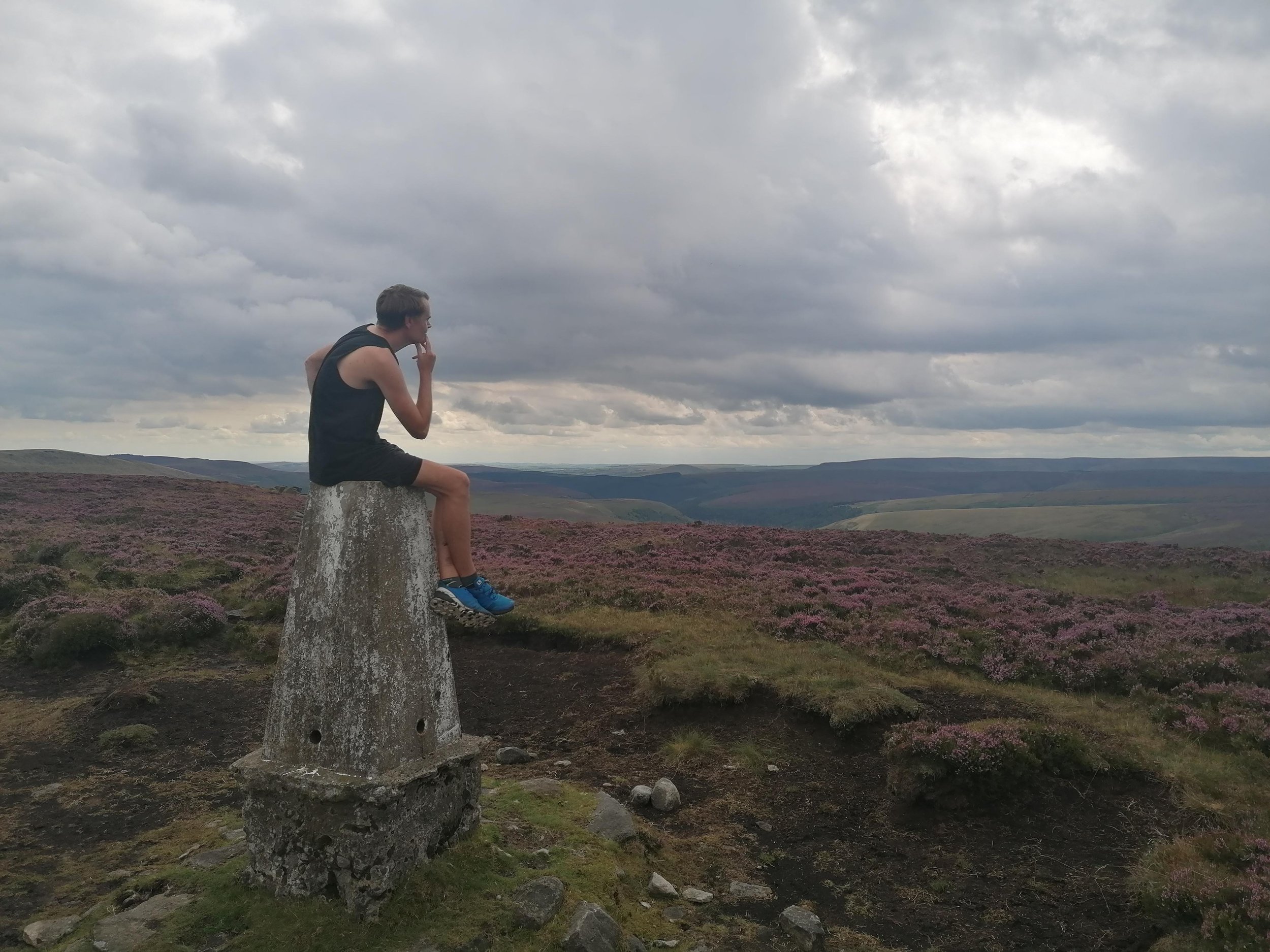Ben ponders on a trig point on the moors