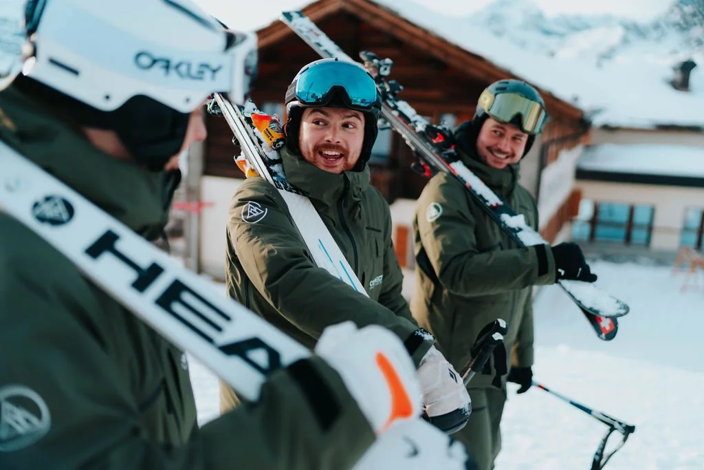 3 of our ski instructors walk with their skis on their shoulders