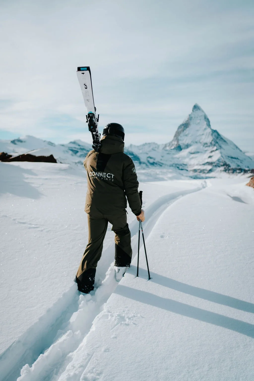Skier walking in the off-piste snow towards the Matterhorn