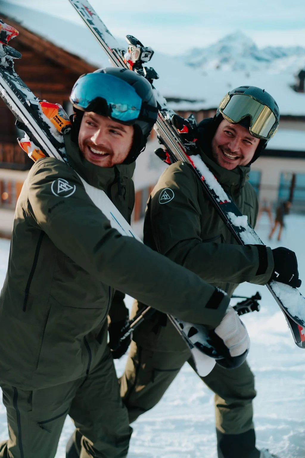 Johnny and Rick walking between lessons with their skis on their shoulder
