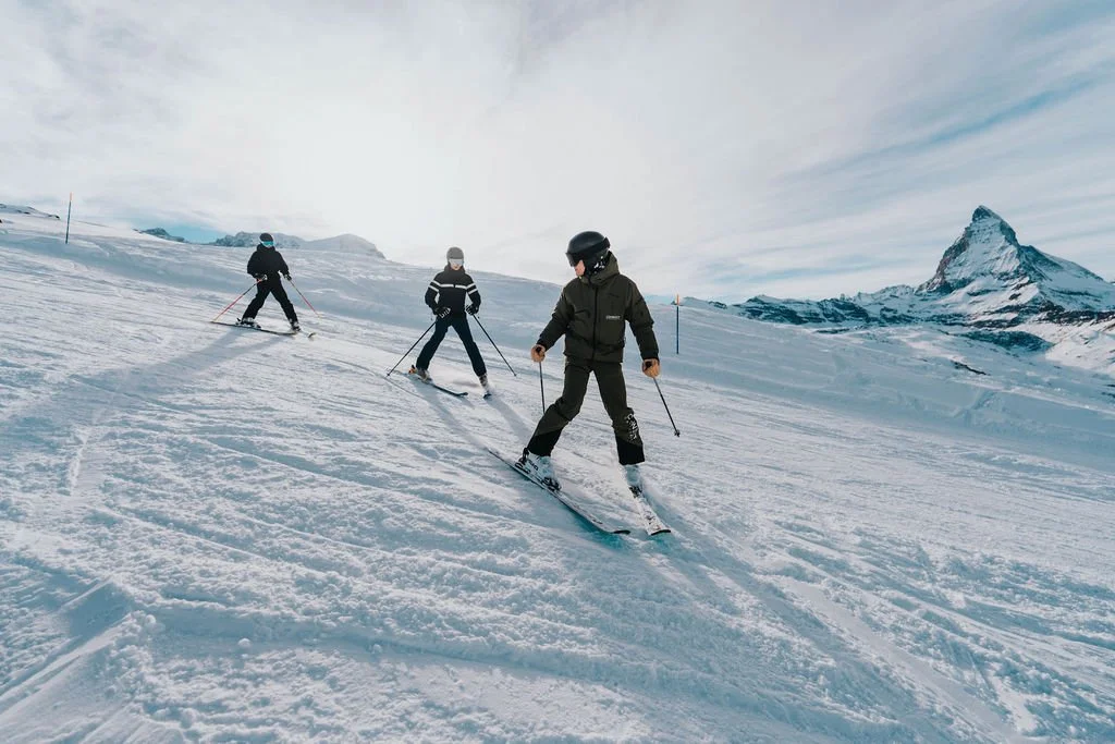 Small group ski lesson descending a gentle slope in Zermatt with the Matterhorn visible in the distance
