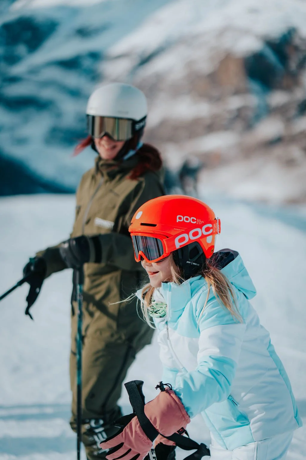 Ski instructor Helen and client laugh together during a ski lesson