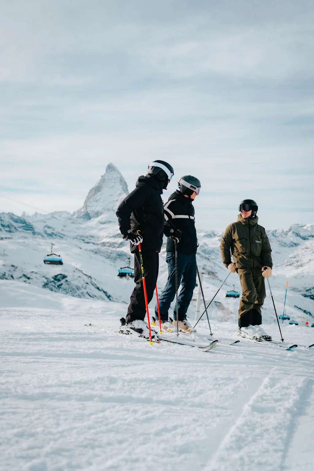 Ski instructor Will is standing on the slopes with two clients with the Matterhorn in the background