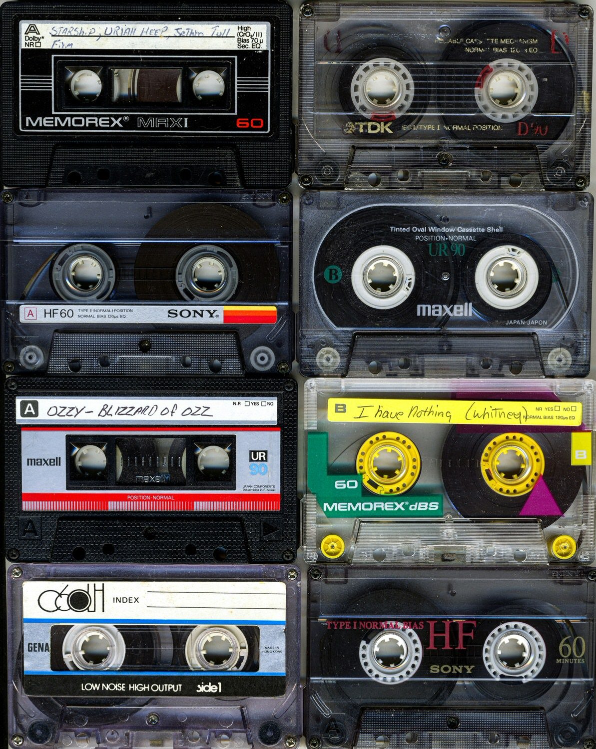 Six audio cassette tapes stacked vertically, with handwritten labels and brand markings such as Sony and Maxell.