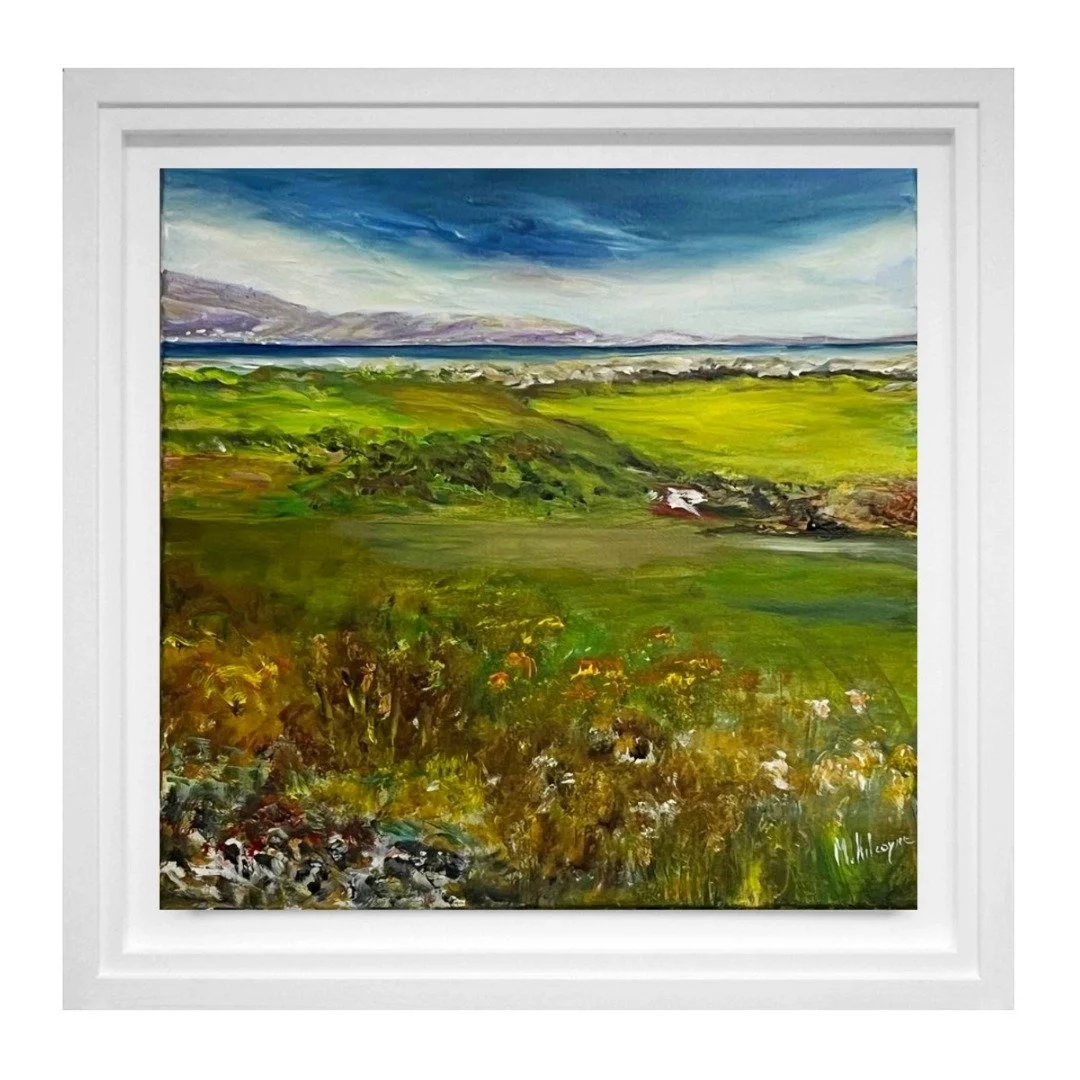 A colorful landscape painting of green fields, distant hills, and a blue sky with clouds, framed in a white border.