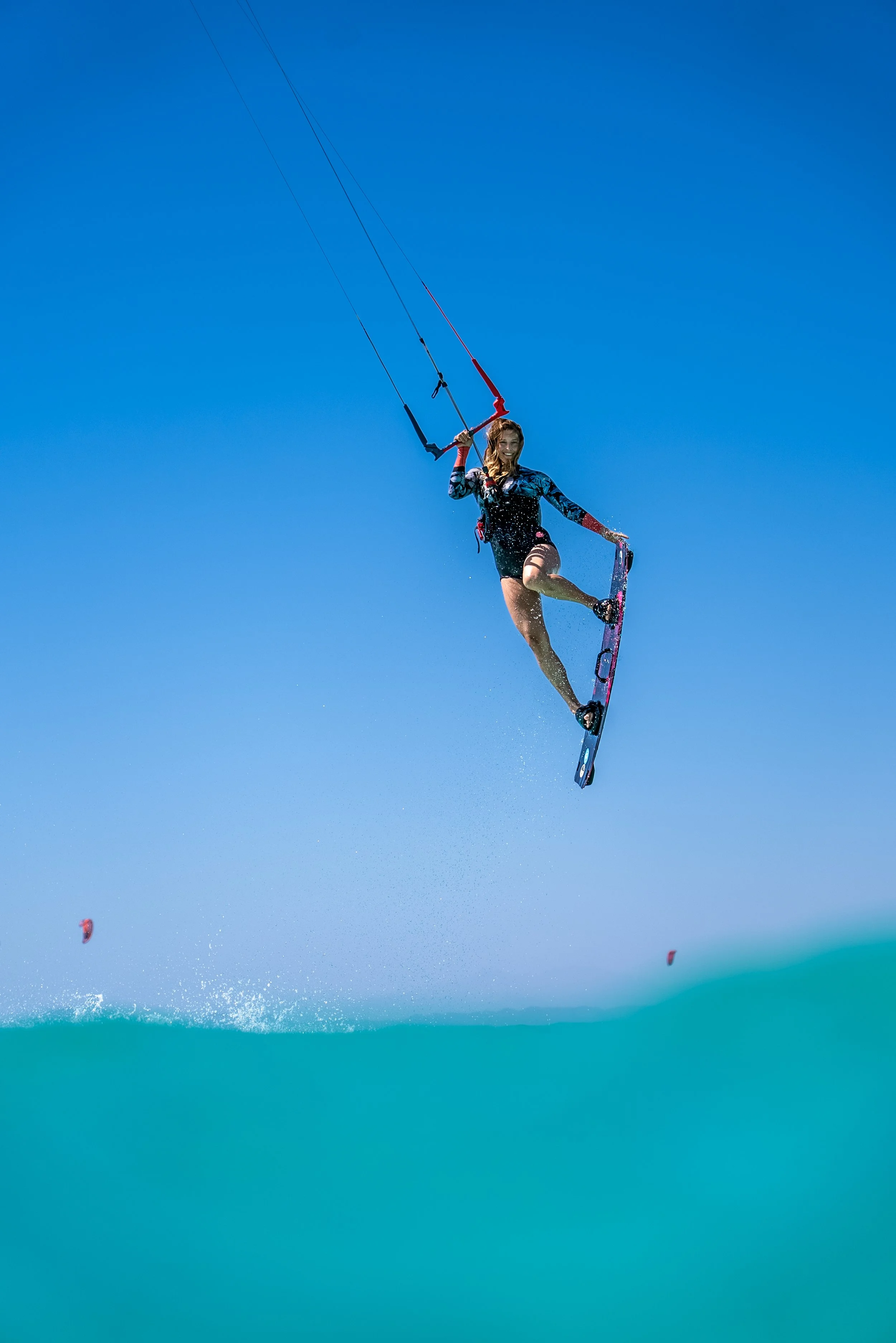 Kite Woman jumping, grabbing her kiteboard