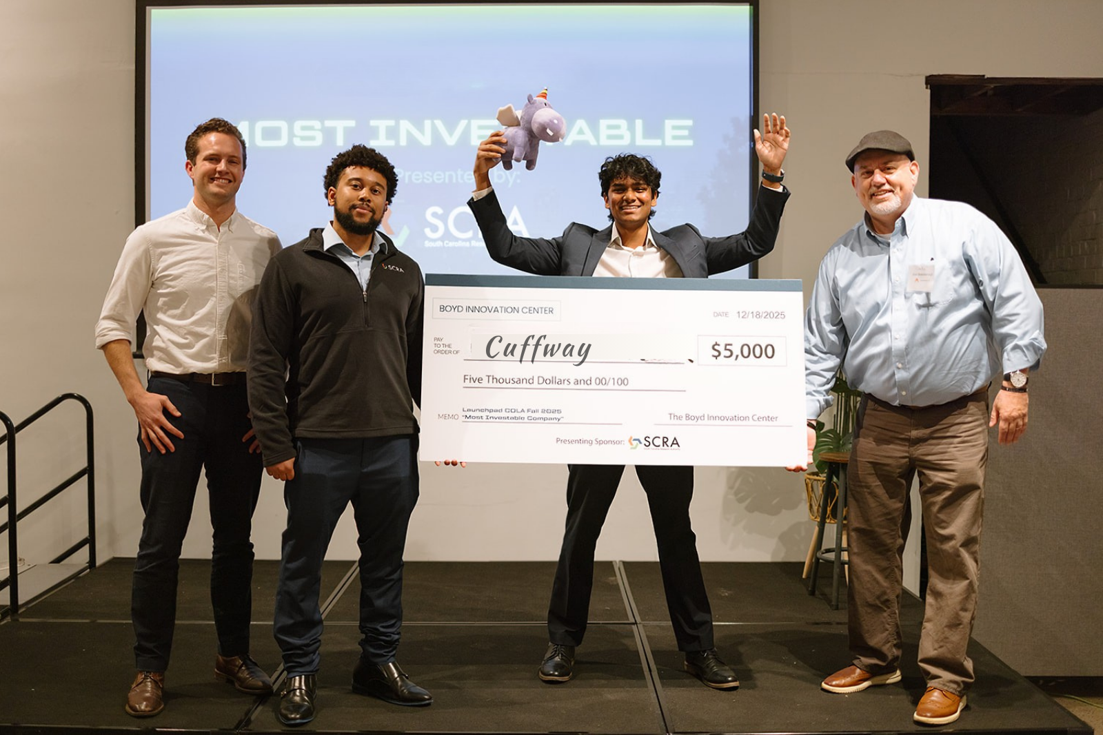 Young man celebrating winning a $5,000 oversized contest check