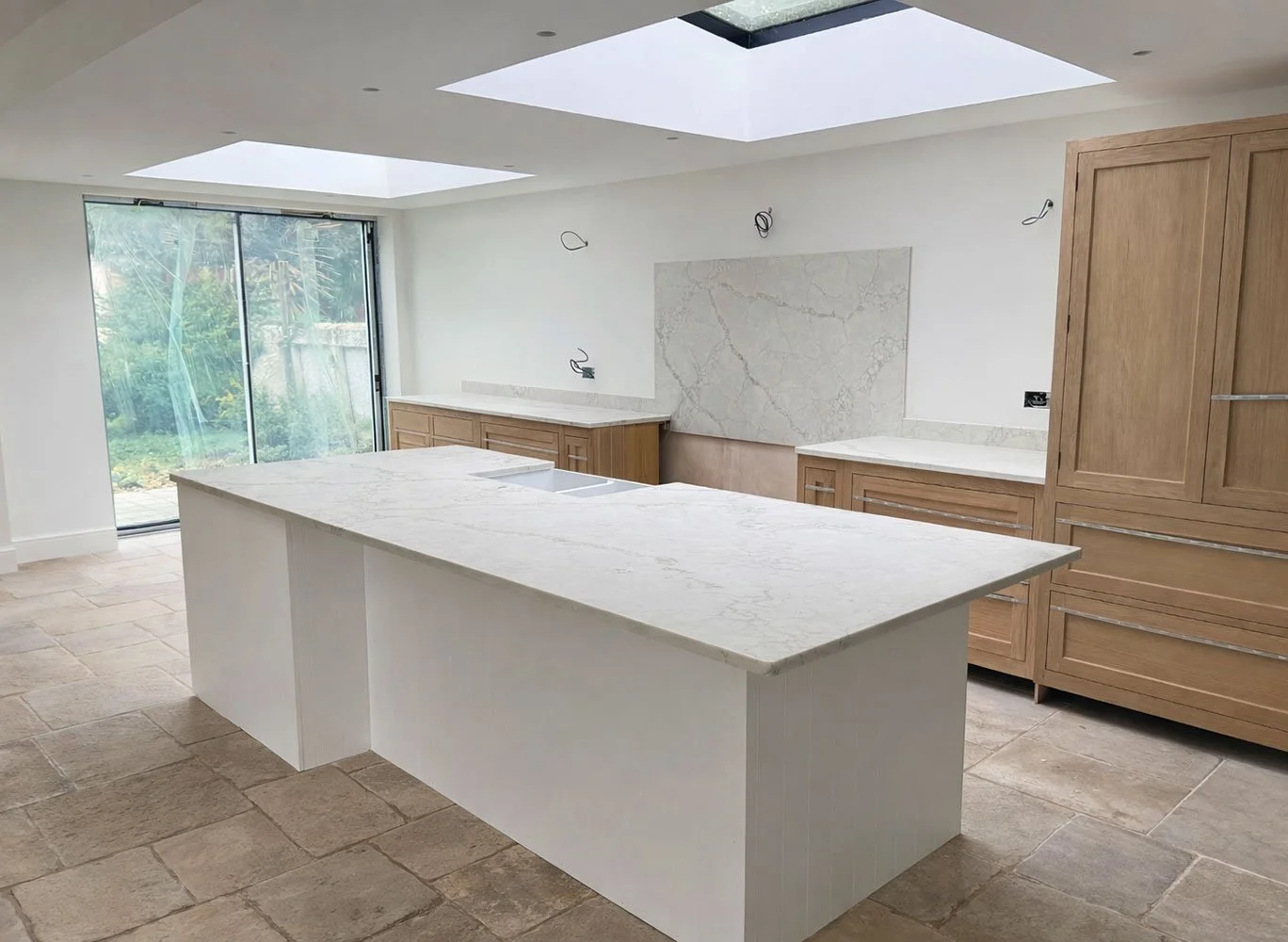 Open-plan kitchen with large island and skylight nearing completion at West Drive extension