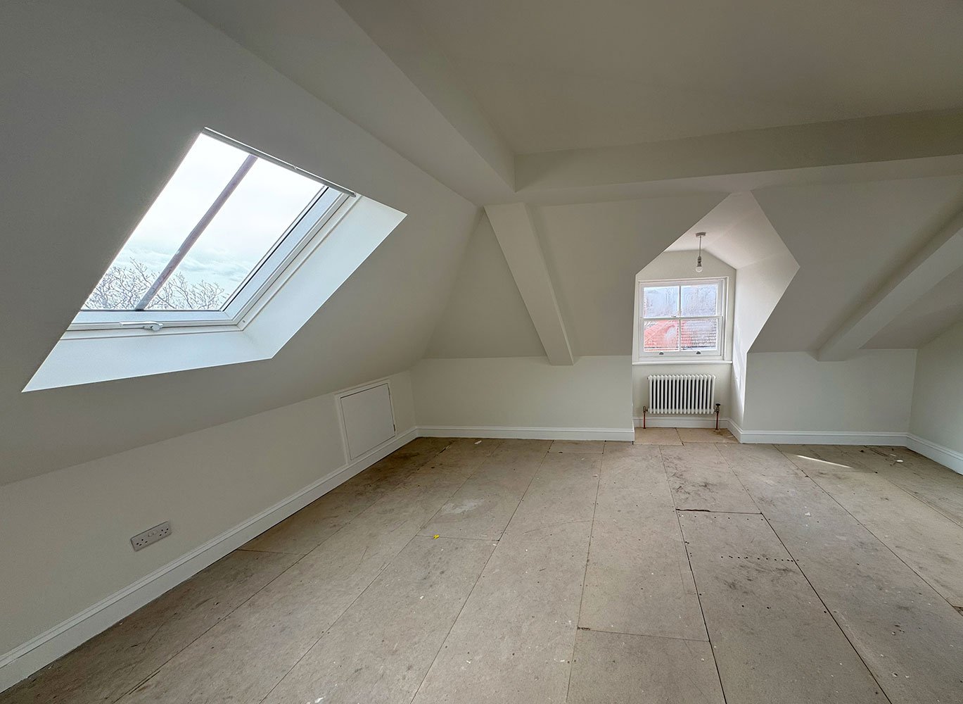 Loft room with rooflight and newly finished plasterwork at West Drive renovation