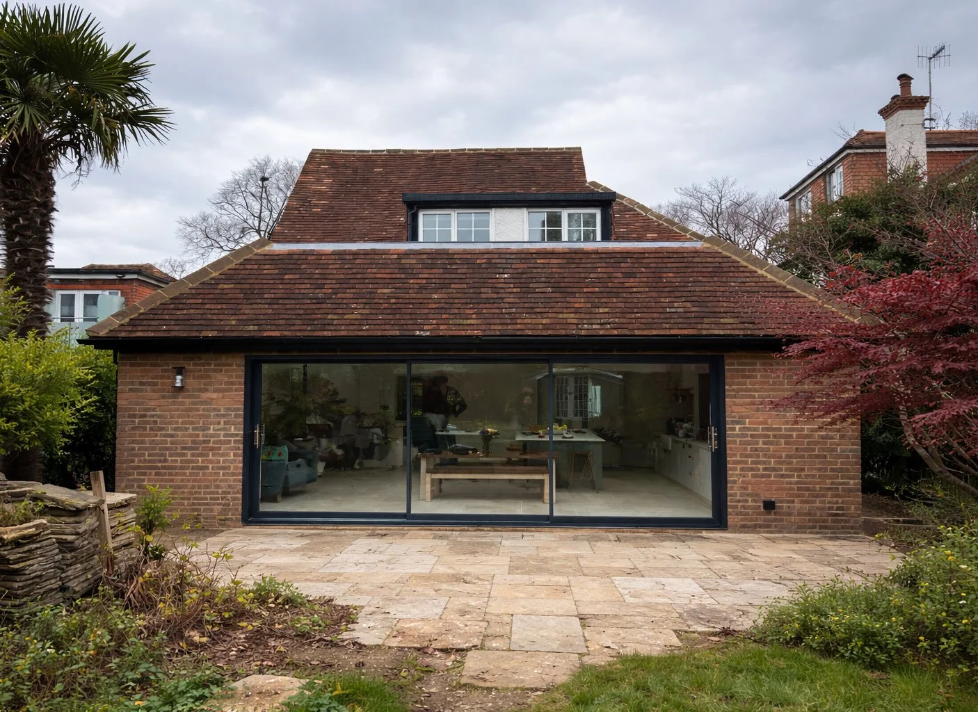 Rear exterior of the Shirley Drive house showing the completed full-width extension with large glazed doors