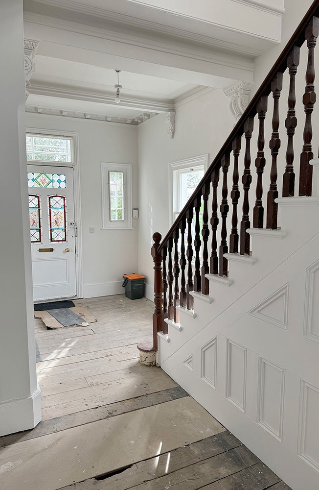 Hallway with original staircase and partially renovated interior at West Drive